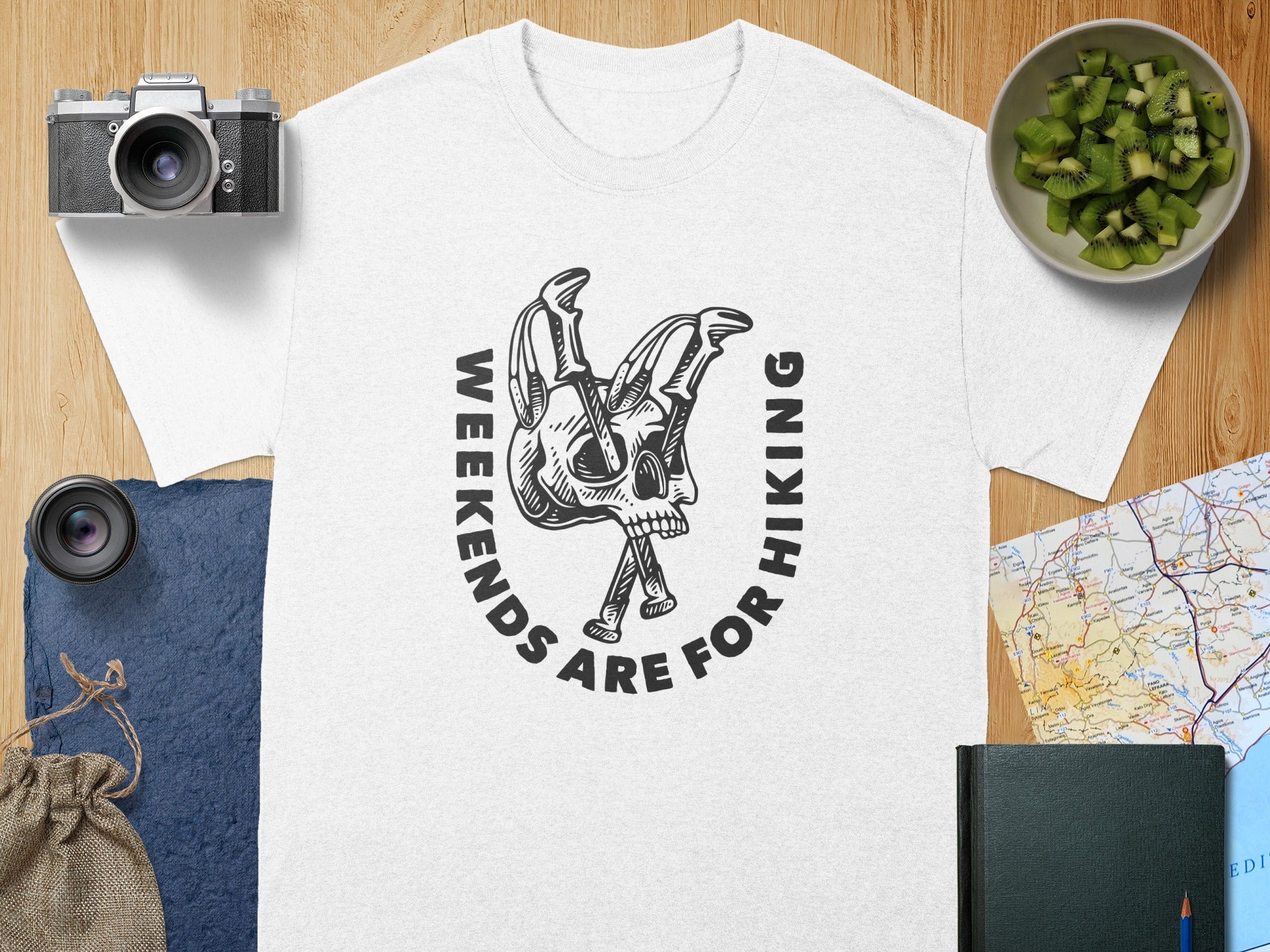 White t-shirt with black graphic of skeleton skull and text "WEEKENDS ARE FOR HIKING".