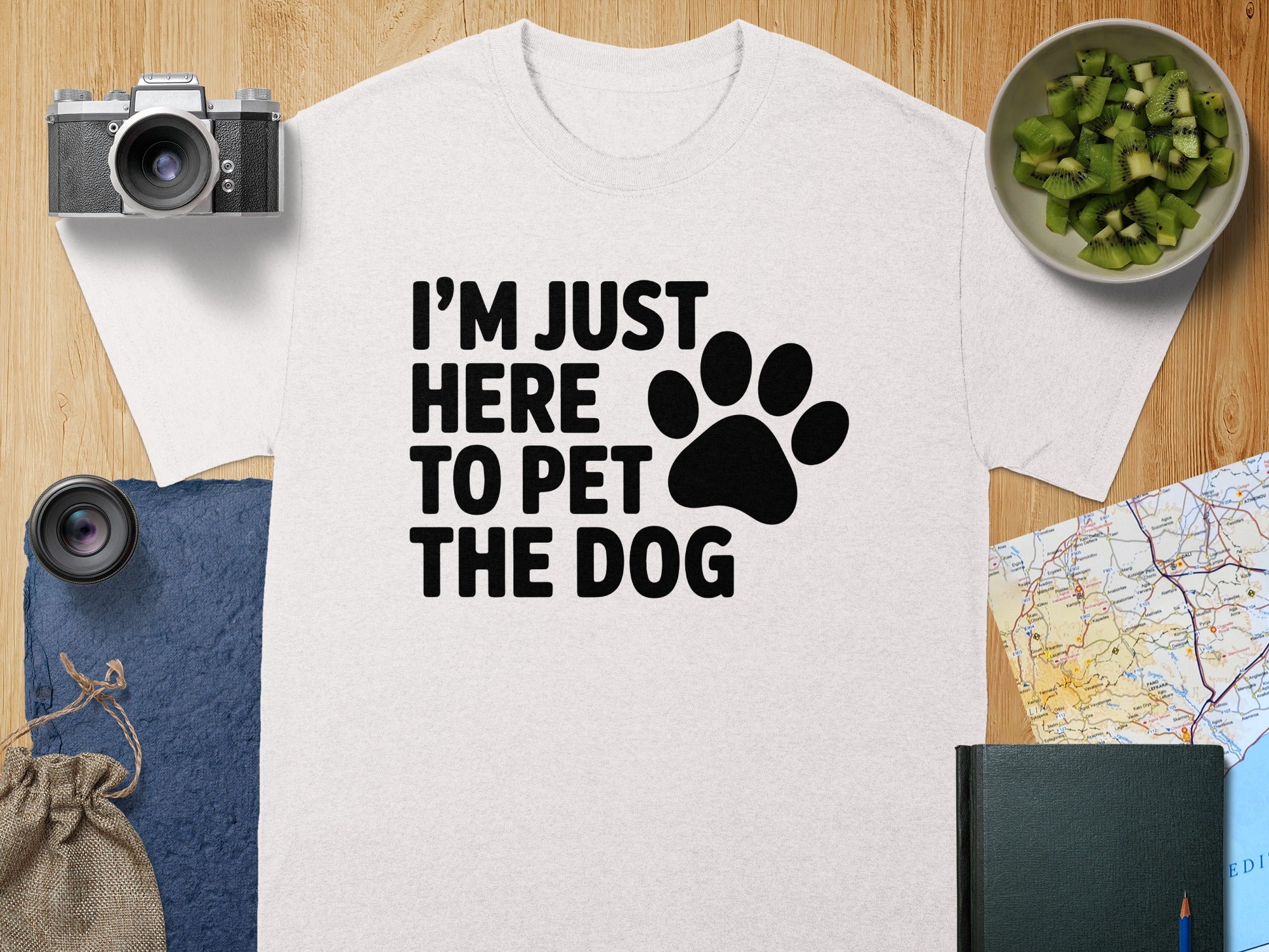 White t-shirt with black text "I'M JUST HERE TO PET THE DOG" and a paw print.
