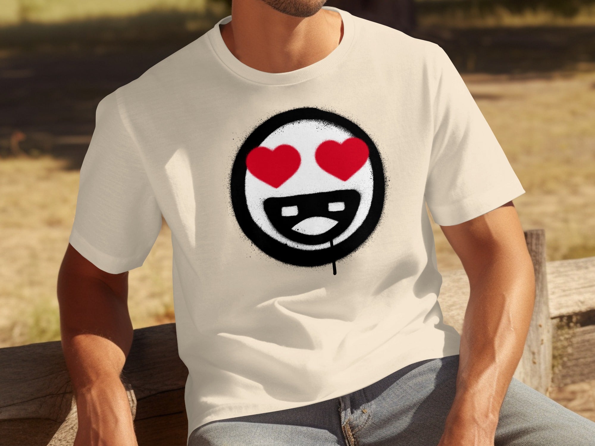 Cream t-shirt with a graphic of a smiley face with red heart eyes and spray paint effect.