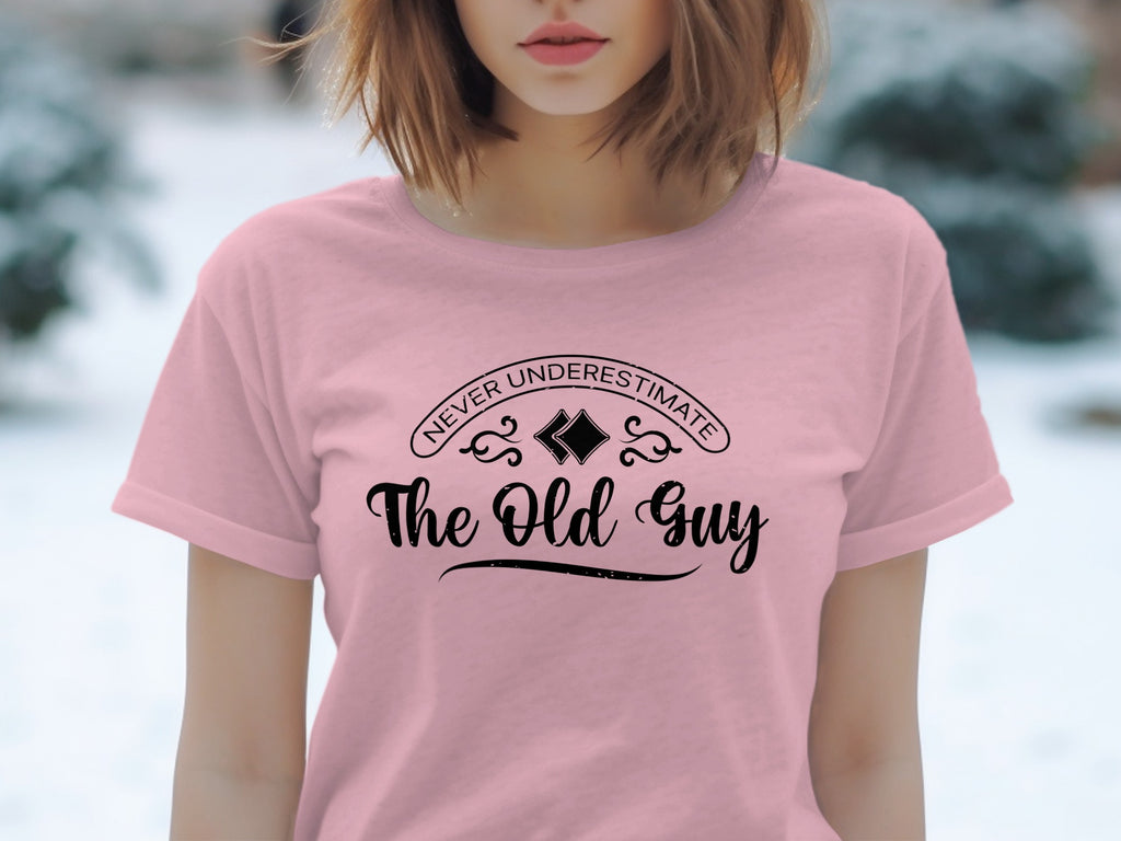 Pink t-shirt with "Never Underestimate The Old Guy" text in black.