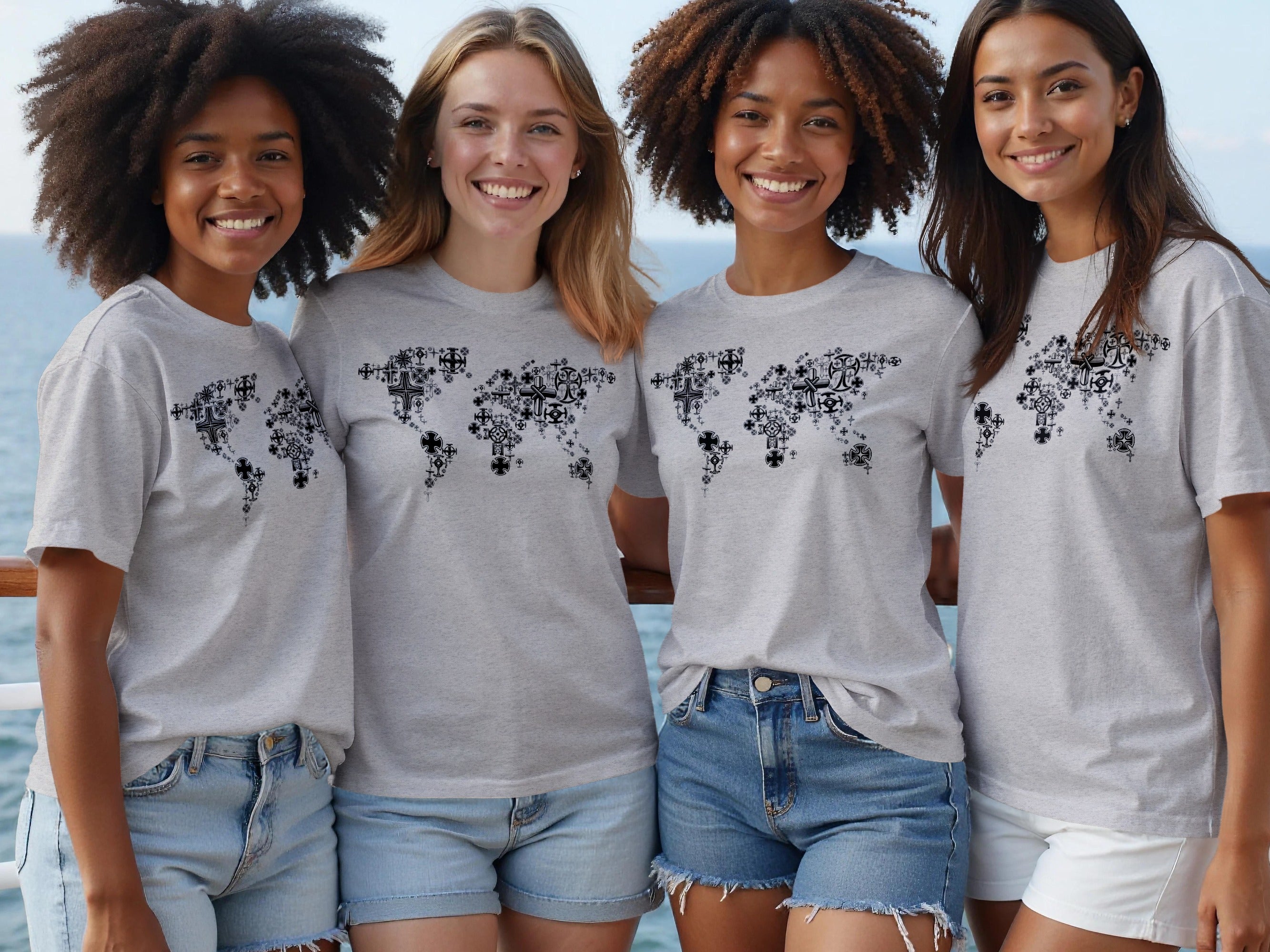 Four women in grey t-shirts featuring a world map design made of crosses.