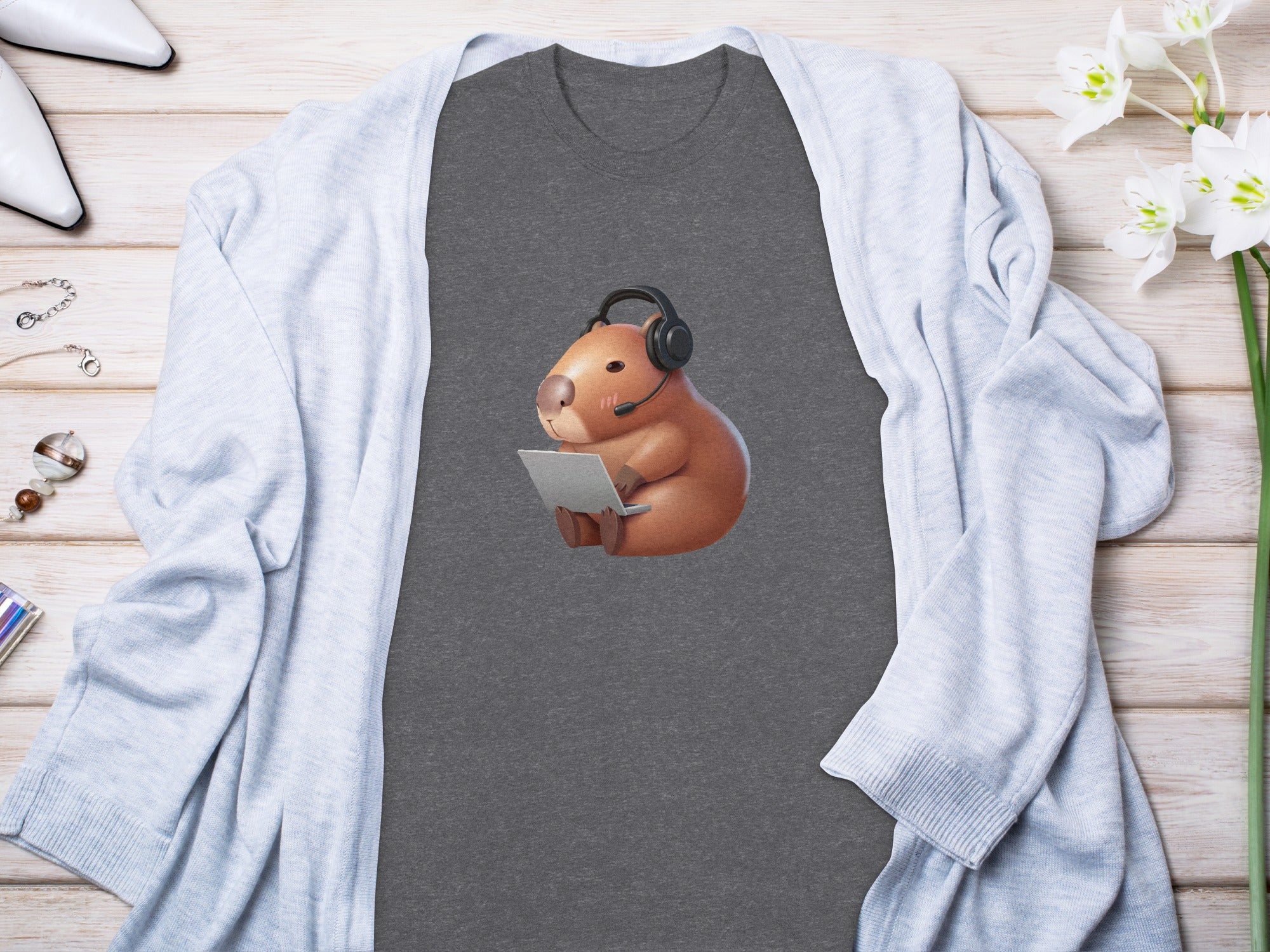 T-shirt with a cute illustration of a capybara wearing headphones and using a laptop.