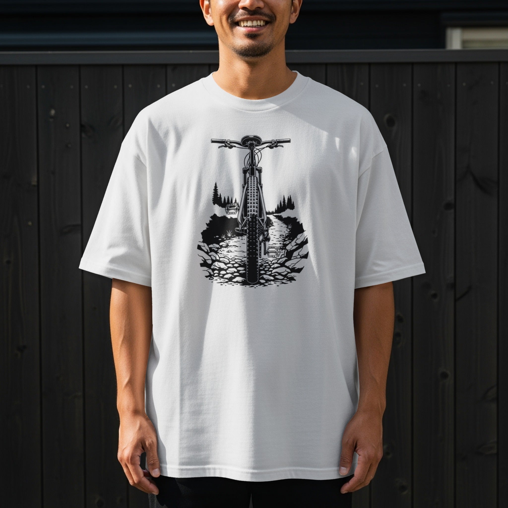 White t-shirt with black graphic of a bicycle on a rocky trail outdoors