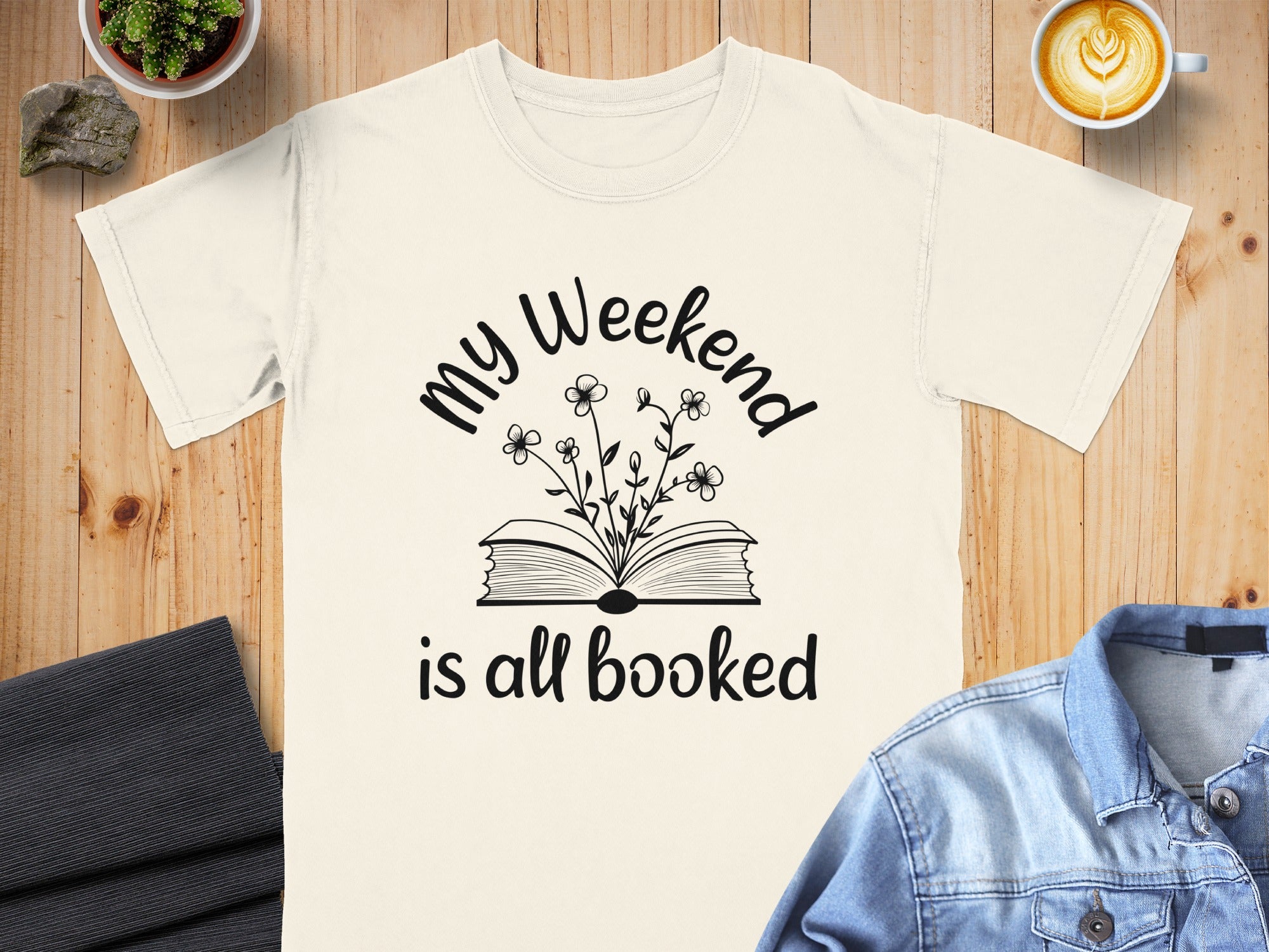 T-shirt with text "My Weekend is all booked" and a book with flowers graphic.