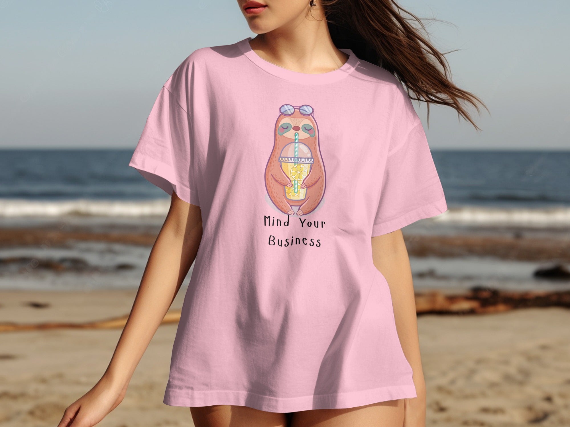 Pink t-shirt with a cartoon sloth drinking lemonade and text "Mind Your Business."