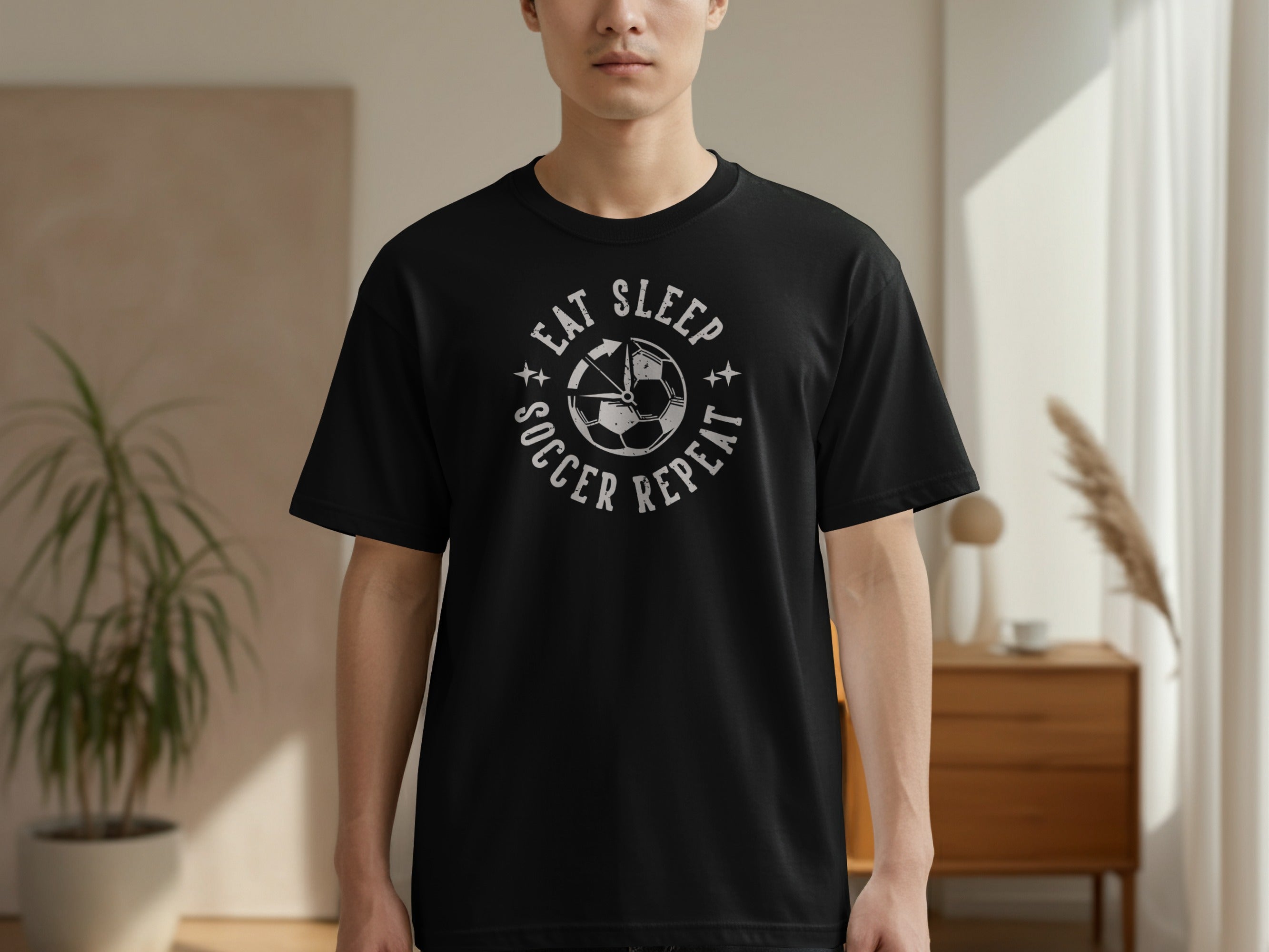 Black t-shirt with "Eat Sleep Soccer Repeat" text and a soccer ball graphic.