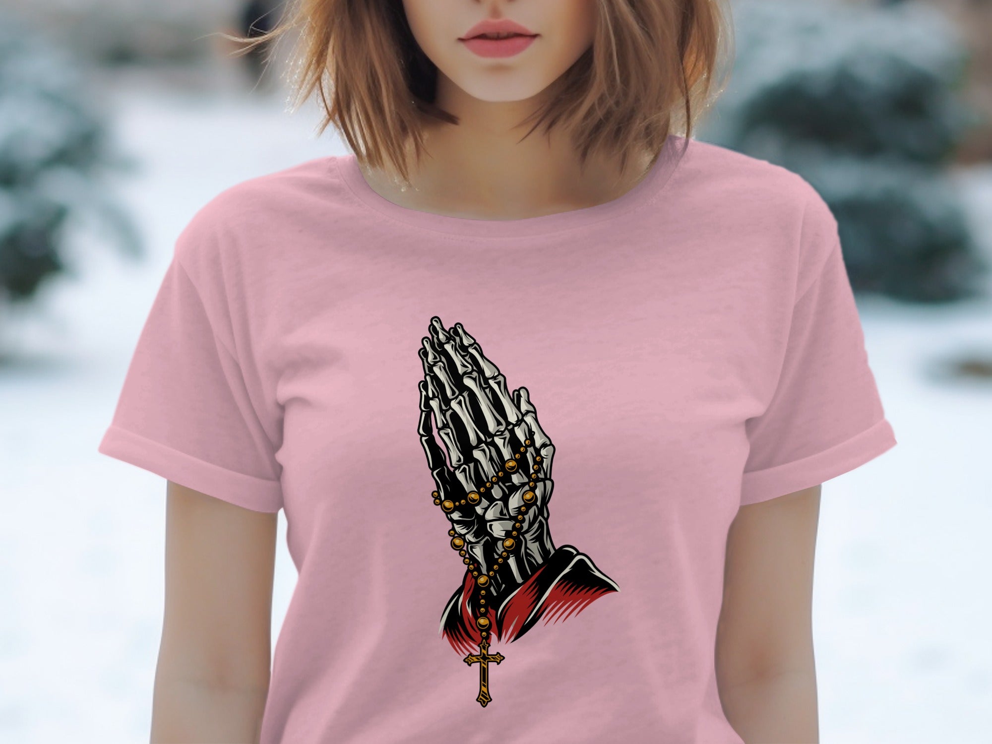Pink t-shirt with skeleton hands praying and wearing a rosary.