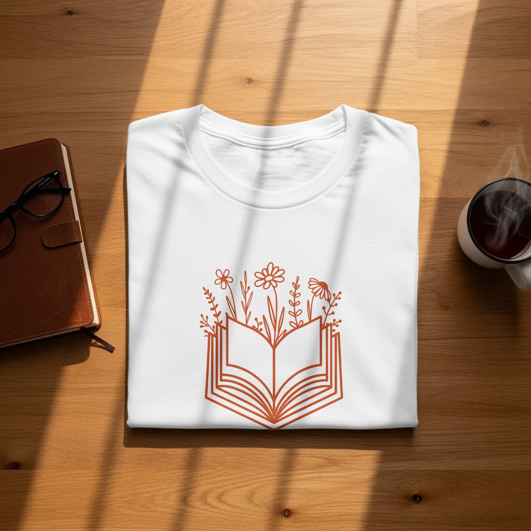White t-shirt with an open book and floral graphic in terracotta.