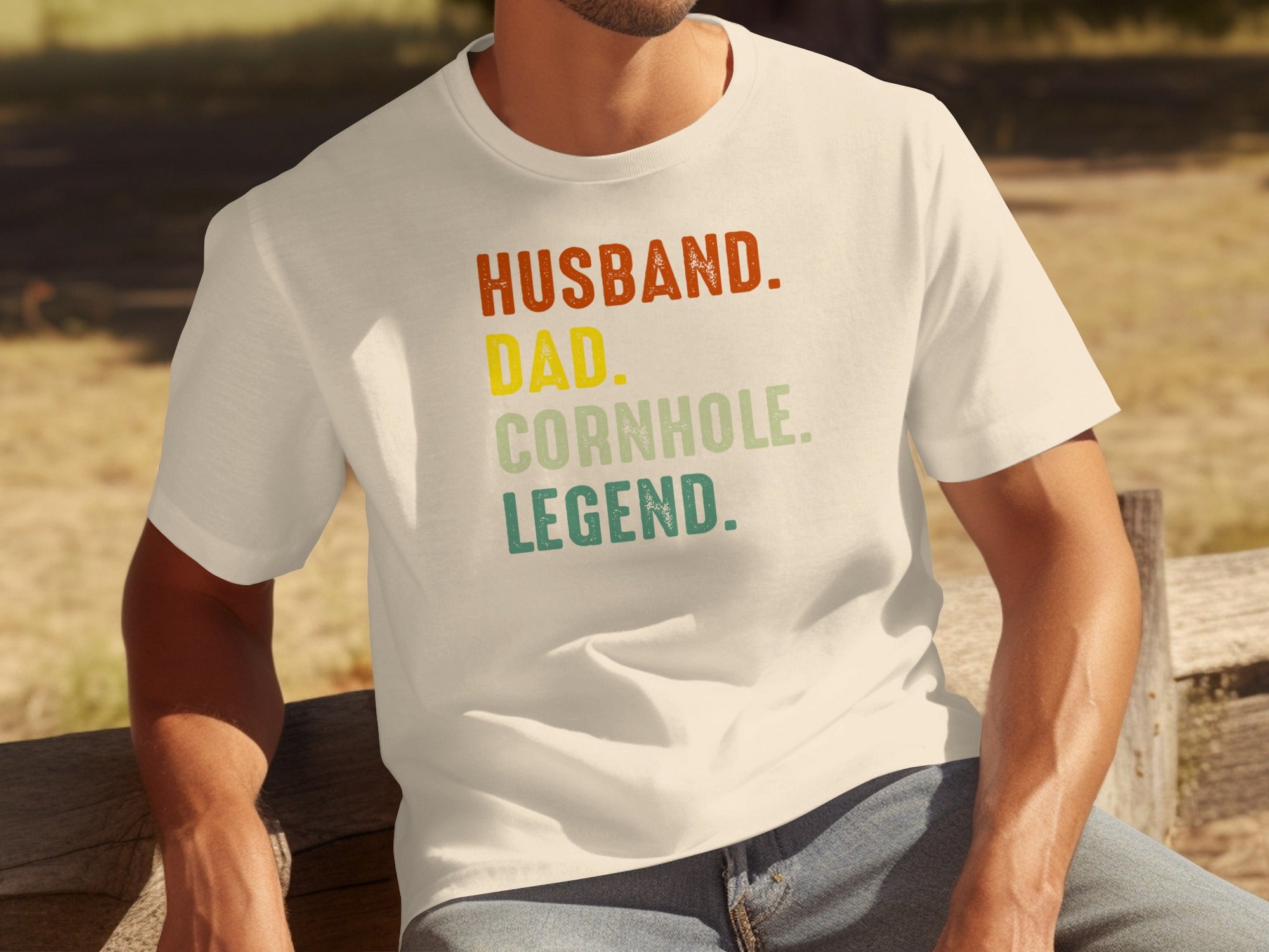 Cream t-shirt with "Husband. Dad. Cornhole Legend." text.