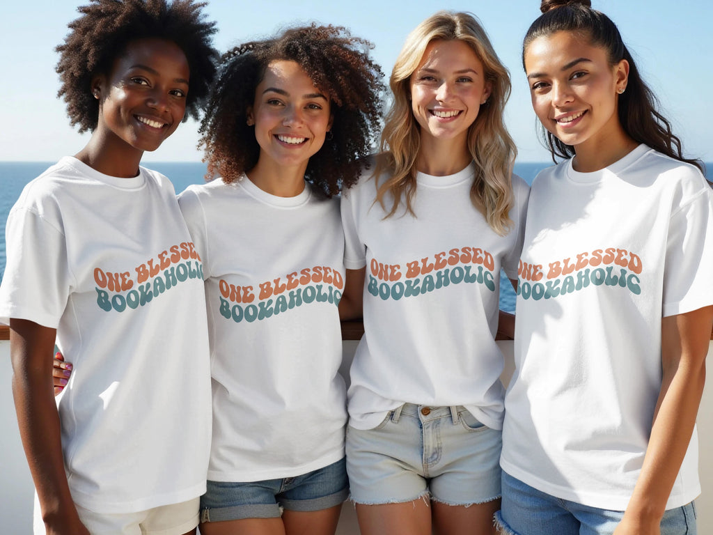 Four women smile wearing white t-shirts with "One Blessed Bookaholic" text.