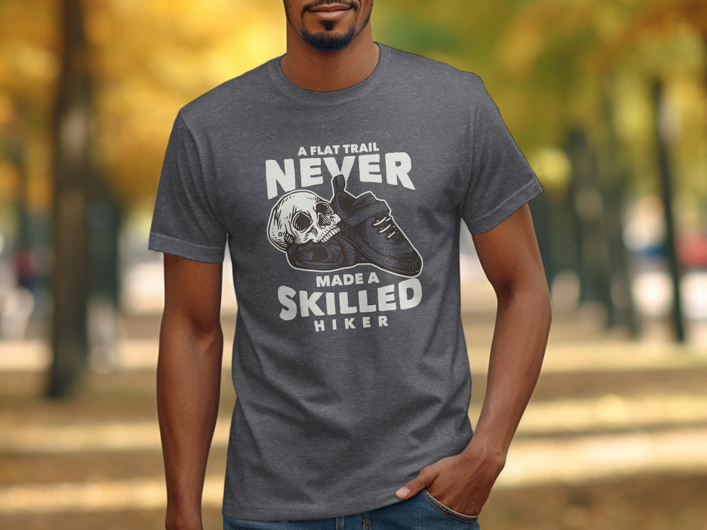 Dark grey t-shirt with "A flat trail never made a skilled hiker" text and skull graphic.
