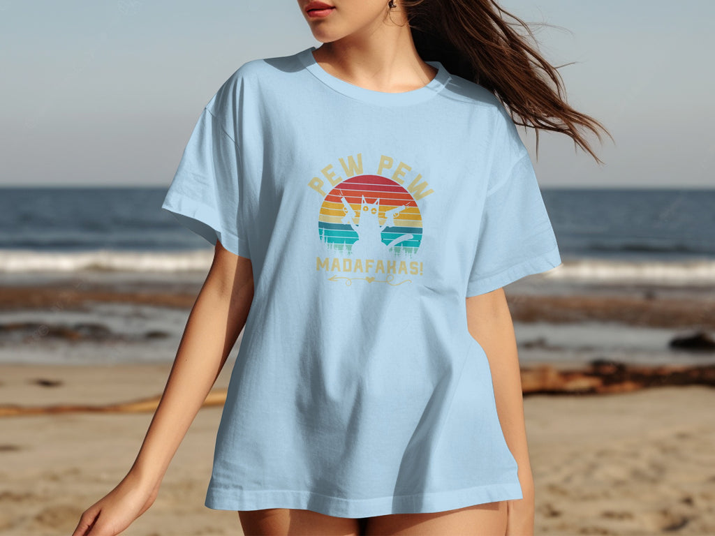 Light blue t-shirt with a cat holding guns and text "PEW PEW MADAFARKAS!".