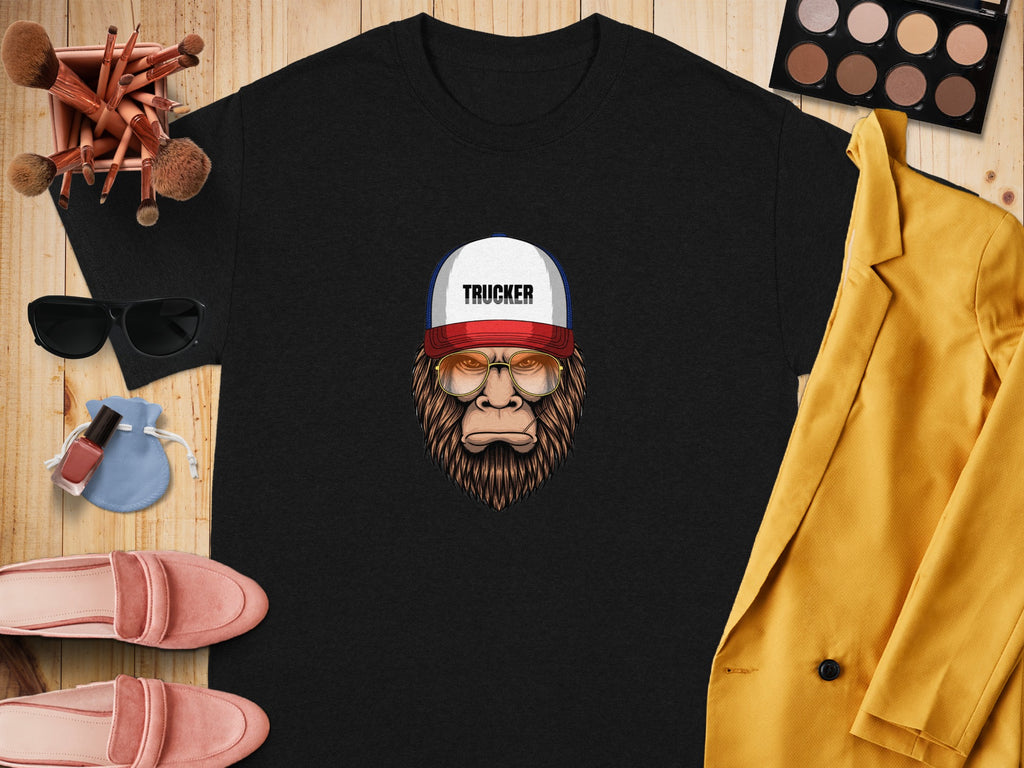 Black t-shirt with a cartoon Bigfoot wearing a trucker hat and sunglasses.