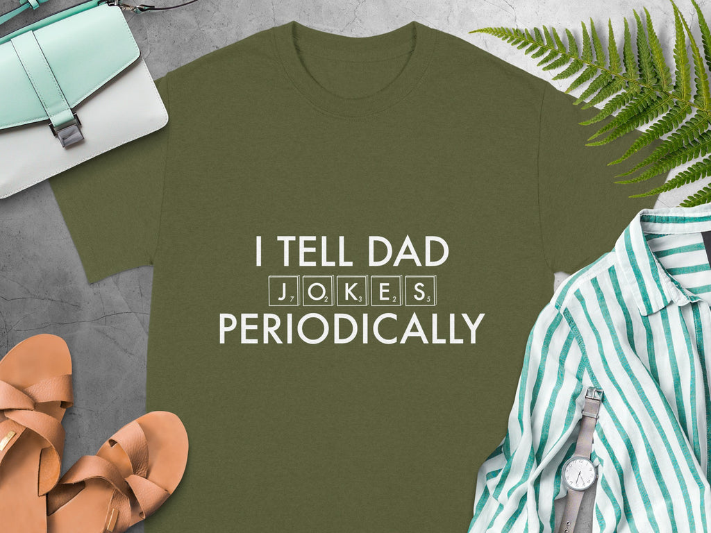 Olive green t-shirt with white text "I TELL DAD J O K E S PERIODICALLY".