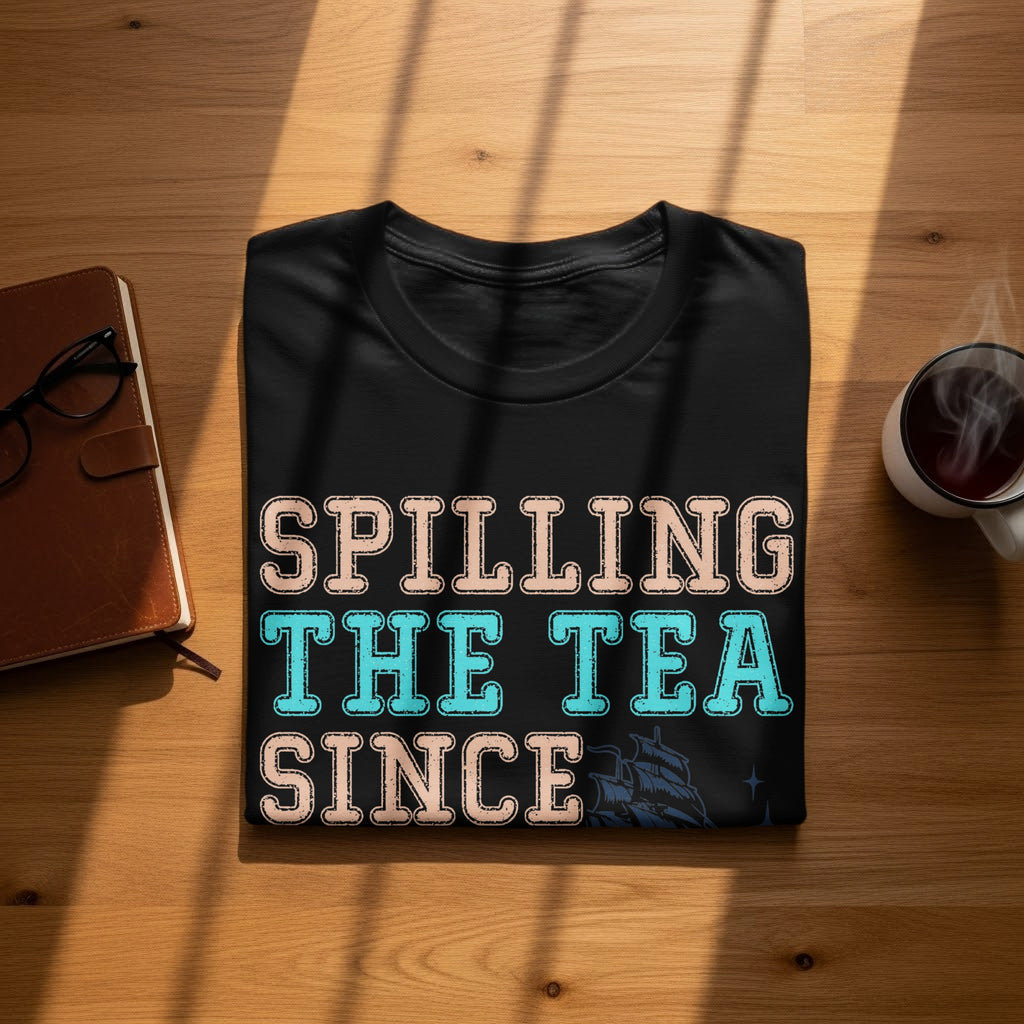 Black t-shirt with text "Spilling The Tea Since" and a ship graphic.