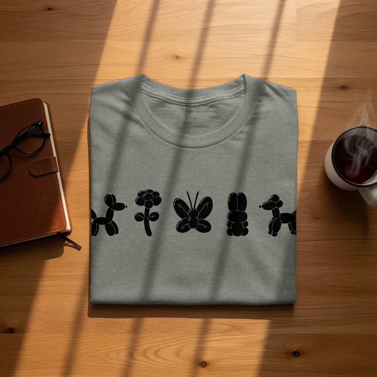 Gray t-shirt with black balloon animal designs of a dog, flower, butterfly, bunny, and dog.