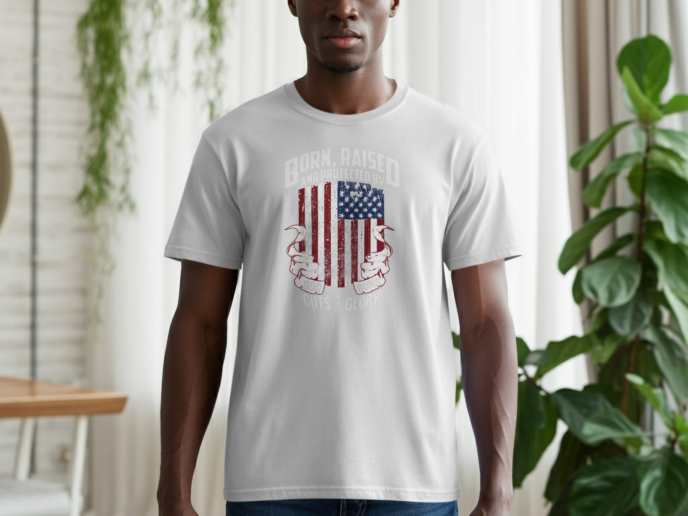 Light grey t-shirt with distressed American flag and text "BORN, RAISED, AND PROTECTED BY GOD, GUNS, AND GLORY."