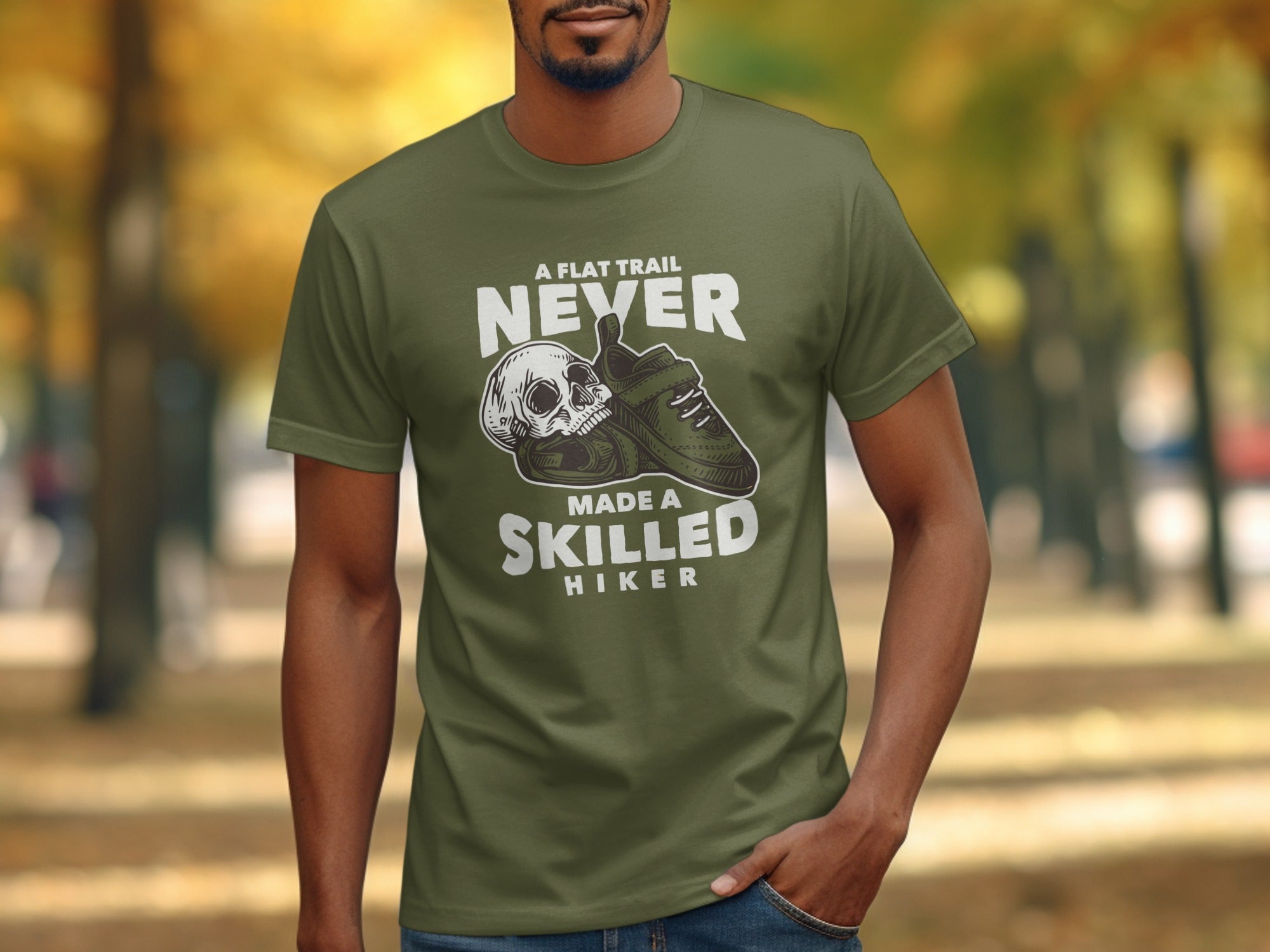 Green t-shirt with a skull and climbing shoe graphic and text "A flat trail never made a skilled hiker".