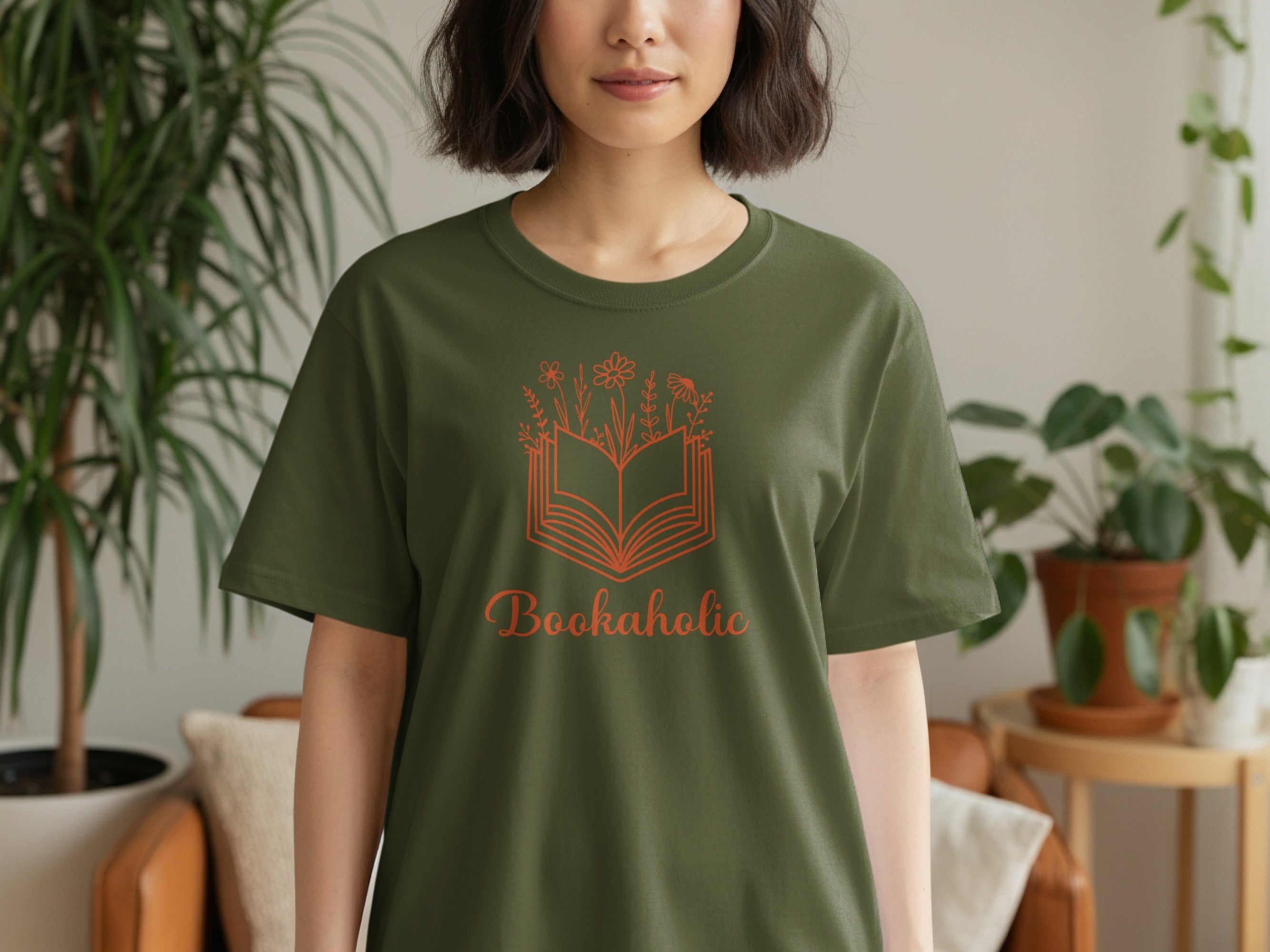 Green t-shirt with an orange open book and floral design and text "Bookaholic".