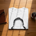 White t-shirt folded with a black shark jaw graphic on the chest.