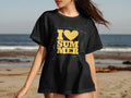 Black t-shirt with yellow text "I ❤️ SUMMER" on a beach background.