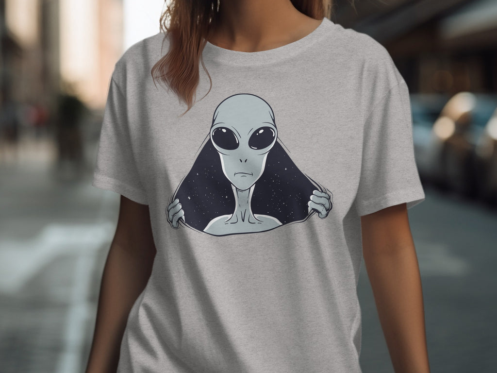 Grey t-shirt with a graphic of a grey alien peeking out from a starry void.