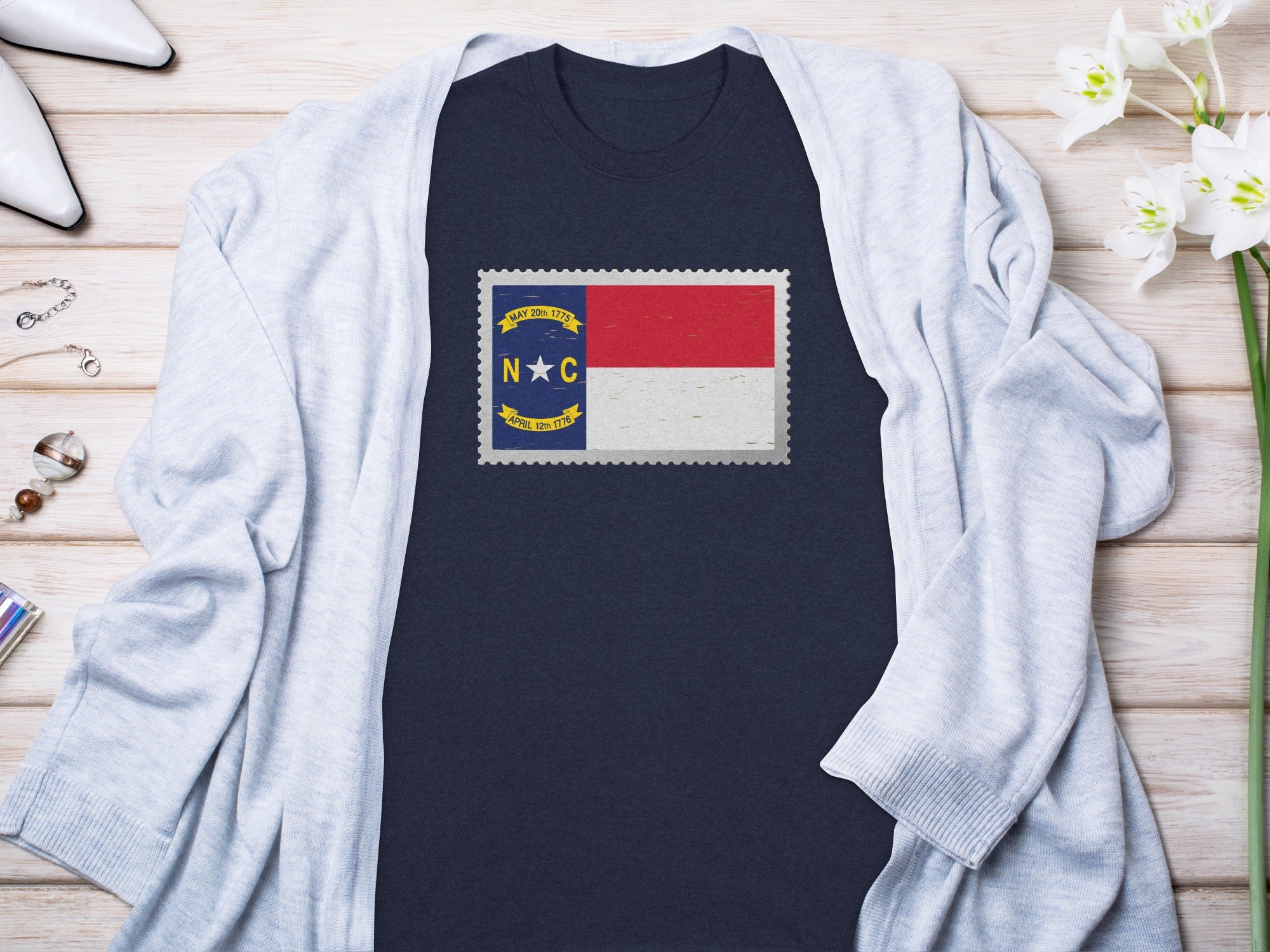 Navy t-shirt with North Carolina flag stamp graphic and light blue cardigan.
