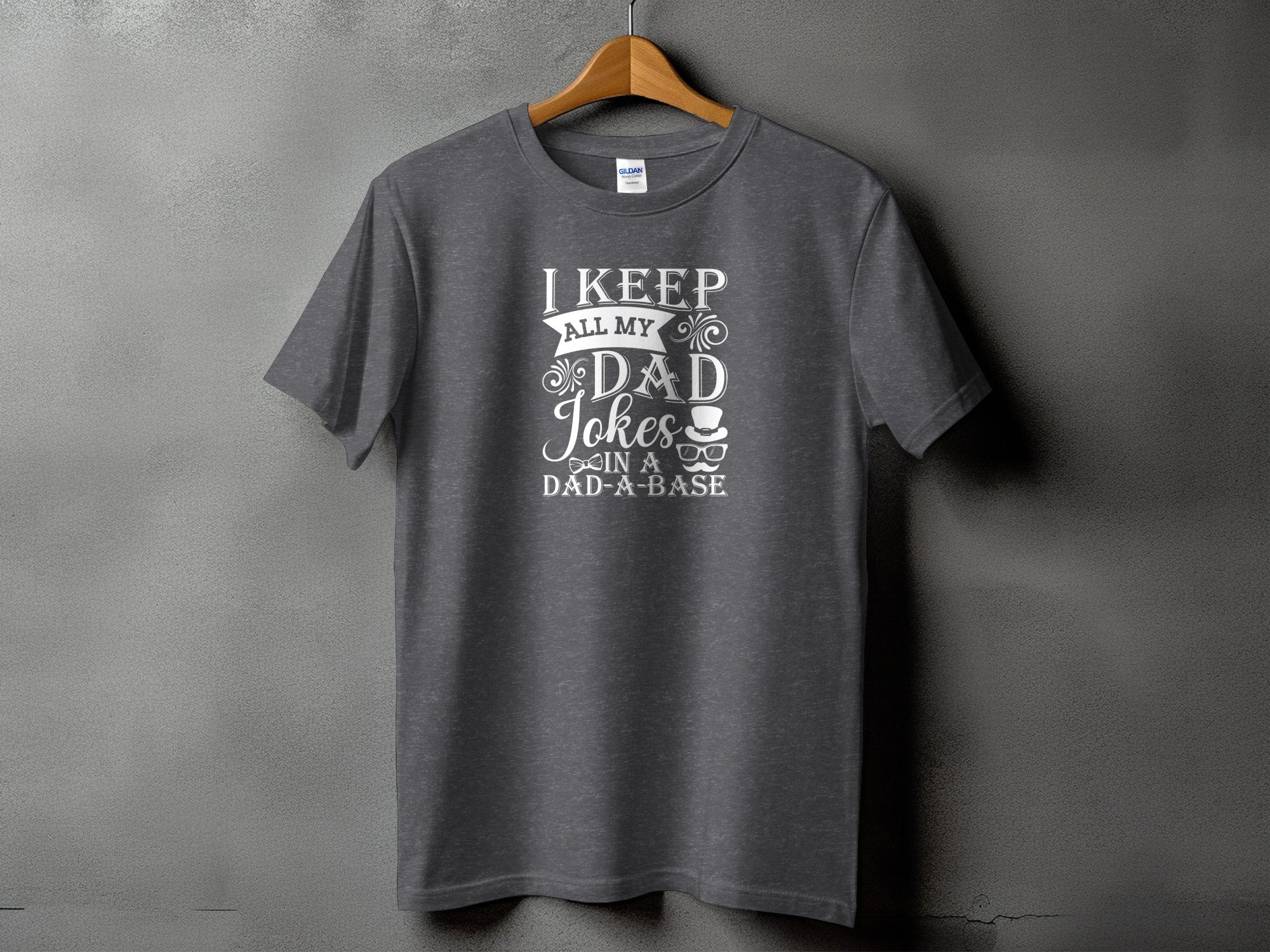 Dark gray t-shirt with "I keep all my dad jokes in a dad-a-base" text and graphics.