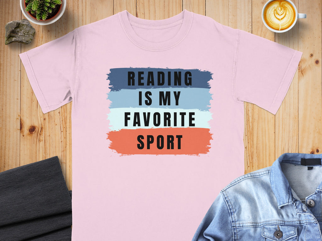 Pink t-shirt with text "Reading is my favorite sport" on colorful stripes.