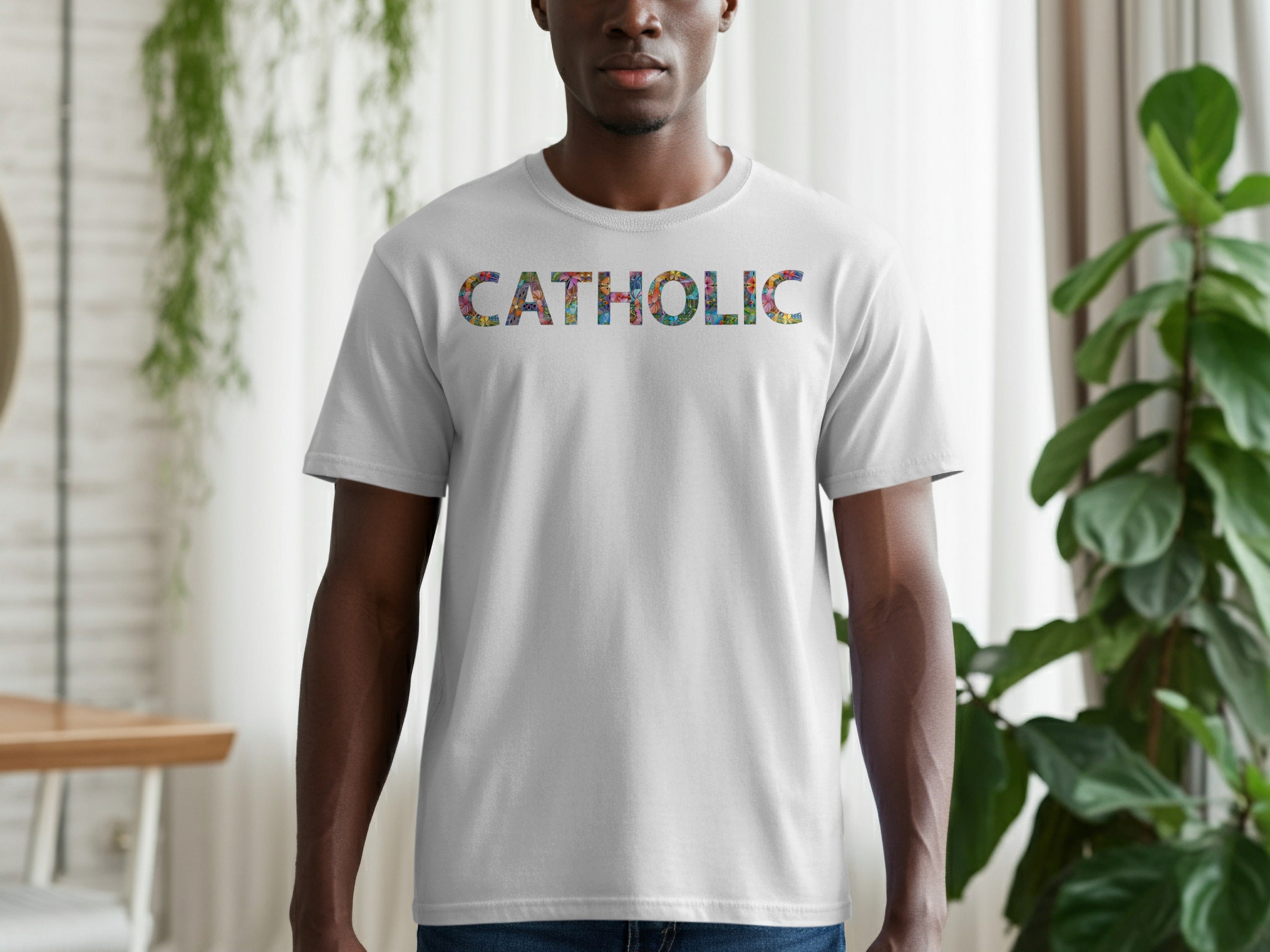 Man wearing a light grey t-shirt with the word "CATHOLIC" in colorful text.