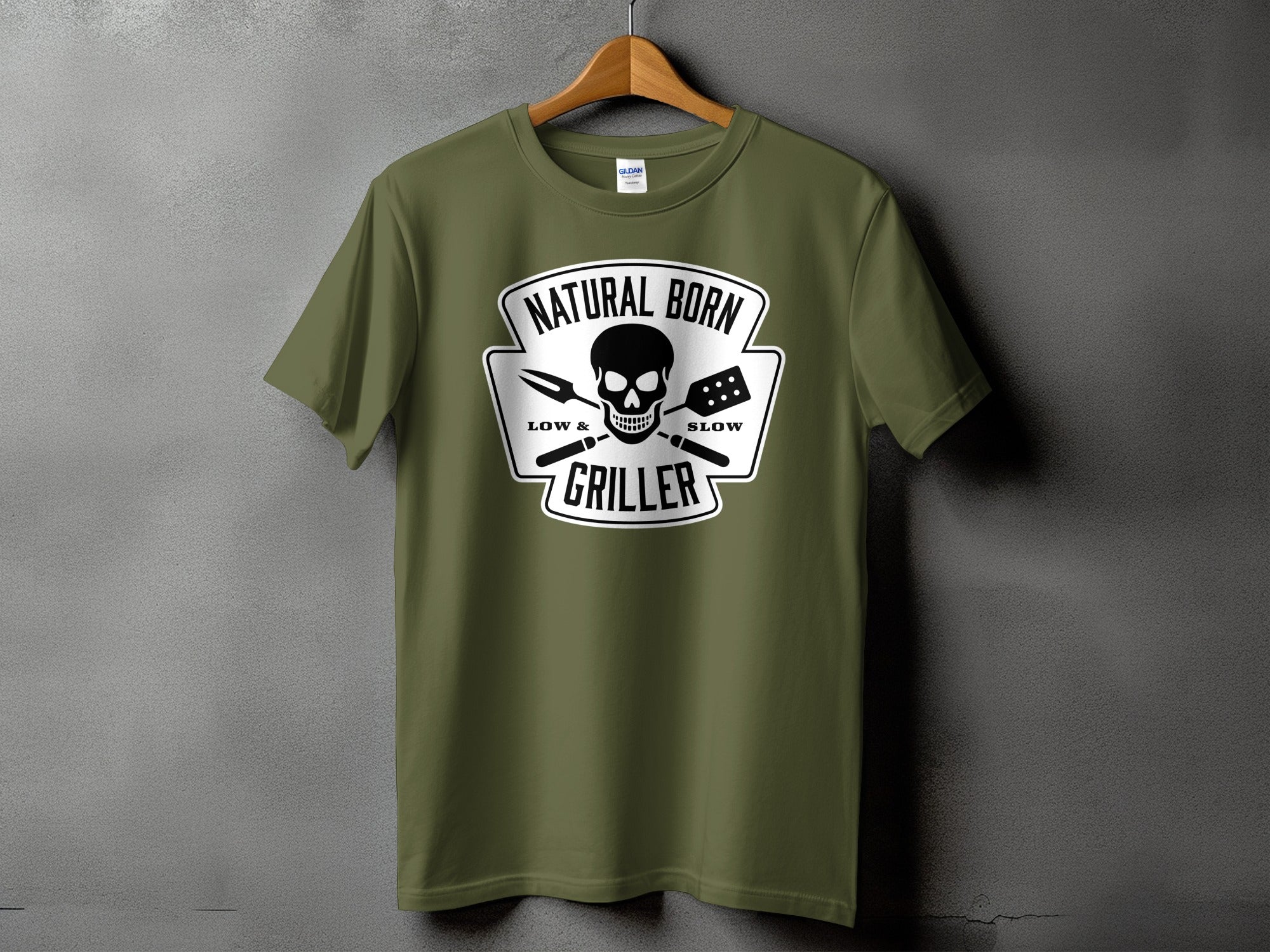 Olive green t-shirt with "Natural Born Griller" skull and barbecue tools graphic.