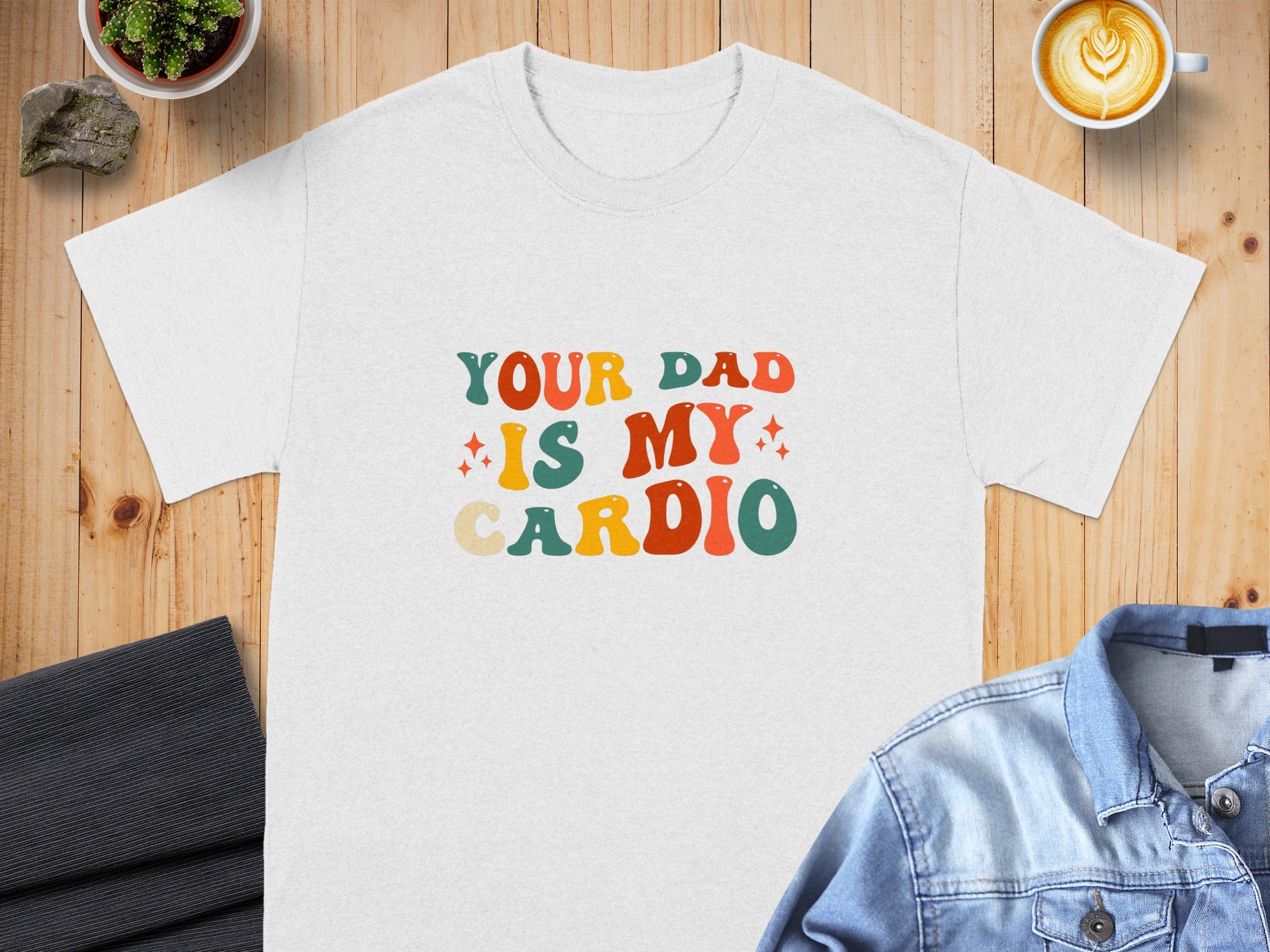 White t-shirt with "Your Dad Is My Cardio" text in retro font.
