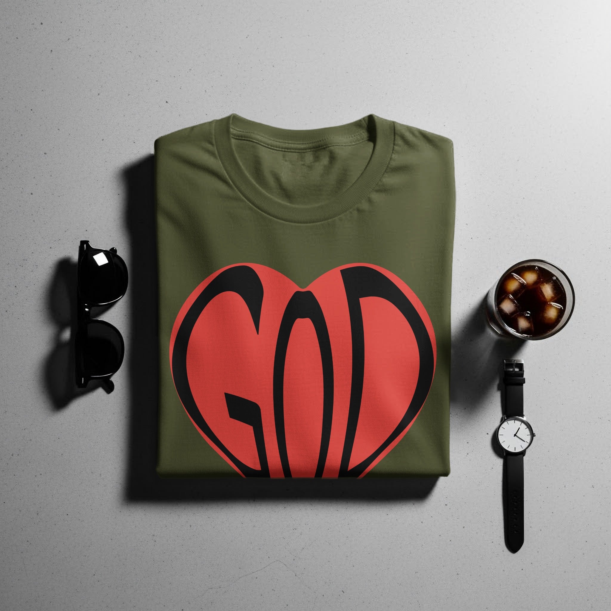 Olive green t-shirt with a red heart graphic with black text "GOD".