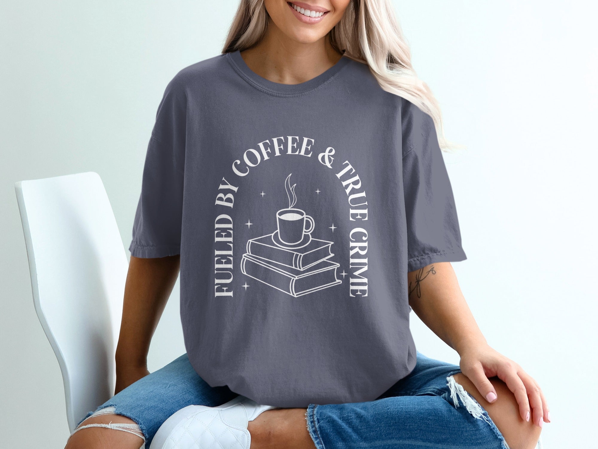 Gray t-shirt with white text "Fueled by Coffee & True Crime" and a coffee cup on books design.