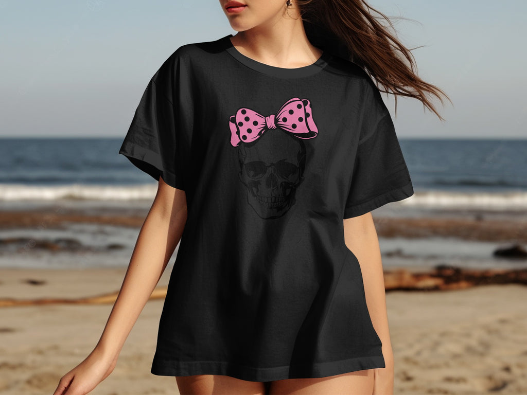 Black t-shirt with a skull graphic and a pink polka dot bow.