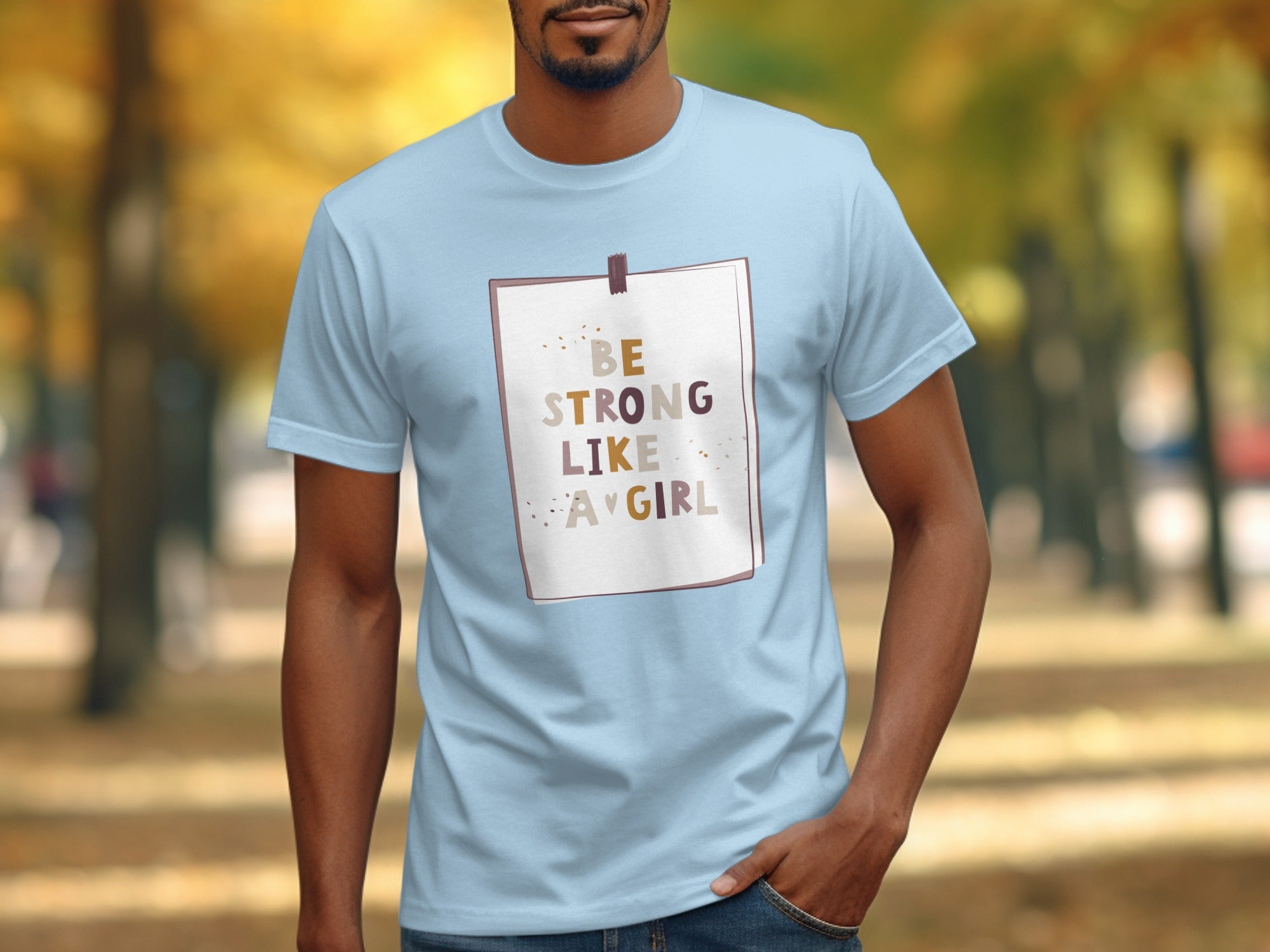 Light blue t-shirt with "BE STRONG LIKE A GIRL" text on a paper graphic.