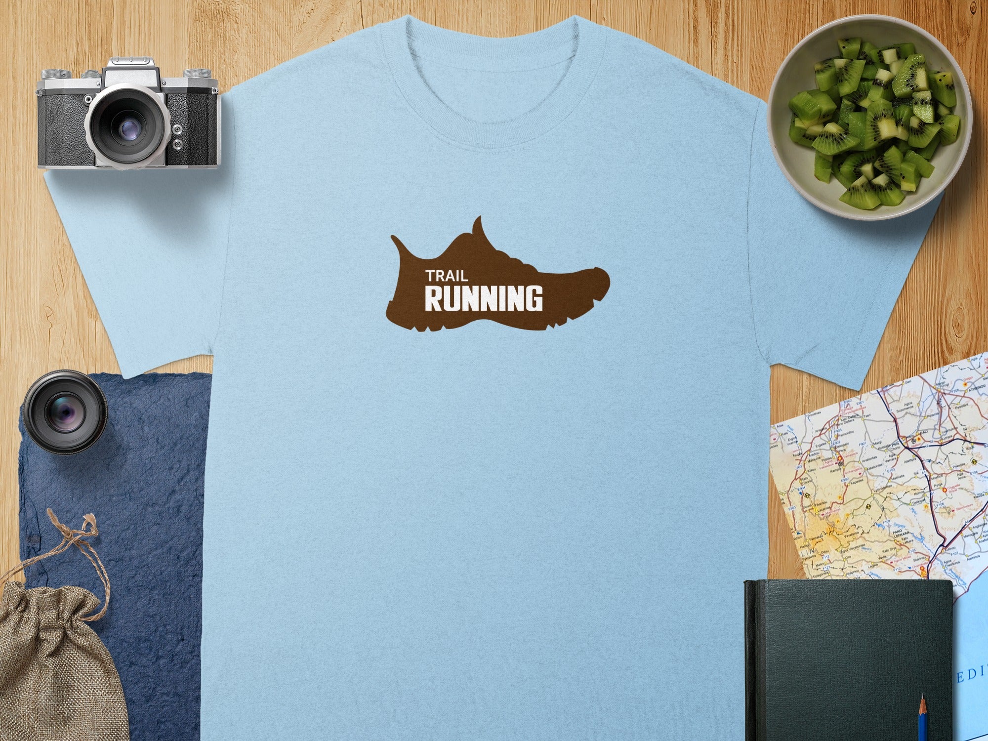 Light blue t-shirt with brown trail running shoe graphic.