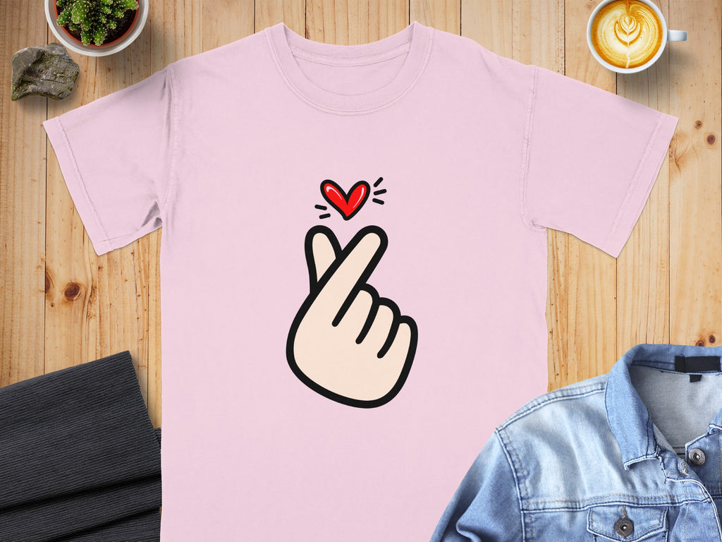 Pink t-shirt with a cartoon hand gesture forming a heart over the chest.