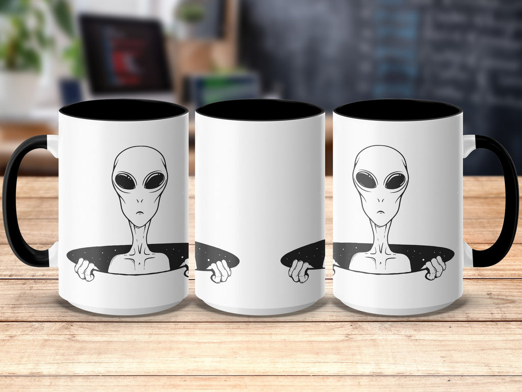 Three white mugs with black interiors and handles featuring an alien peeking out.