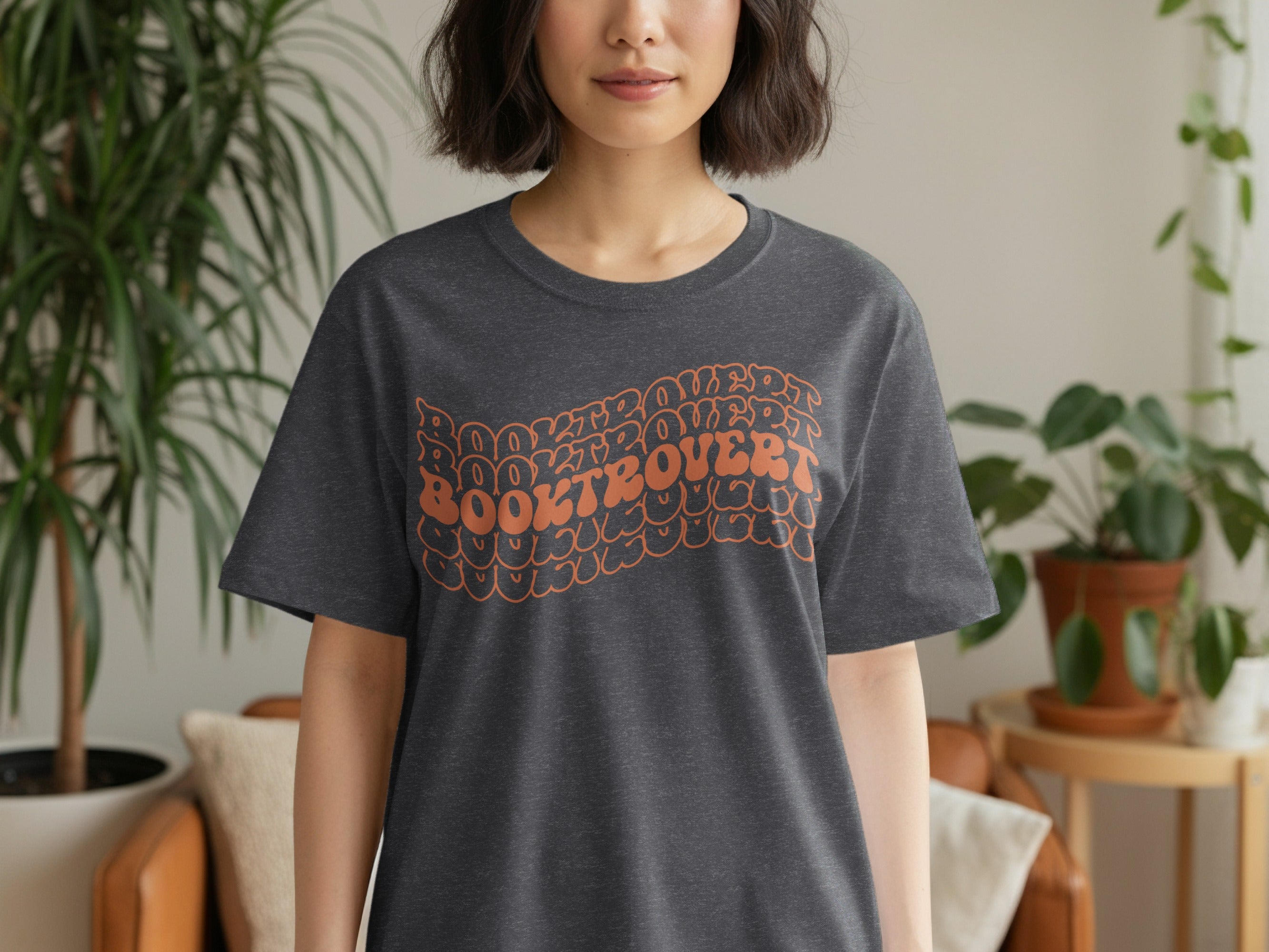Dark gray t-shirt with orange "BOOKTROVERT" text in a bubbly font.