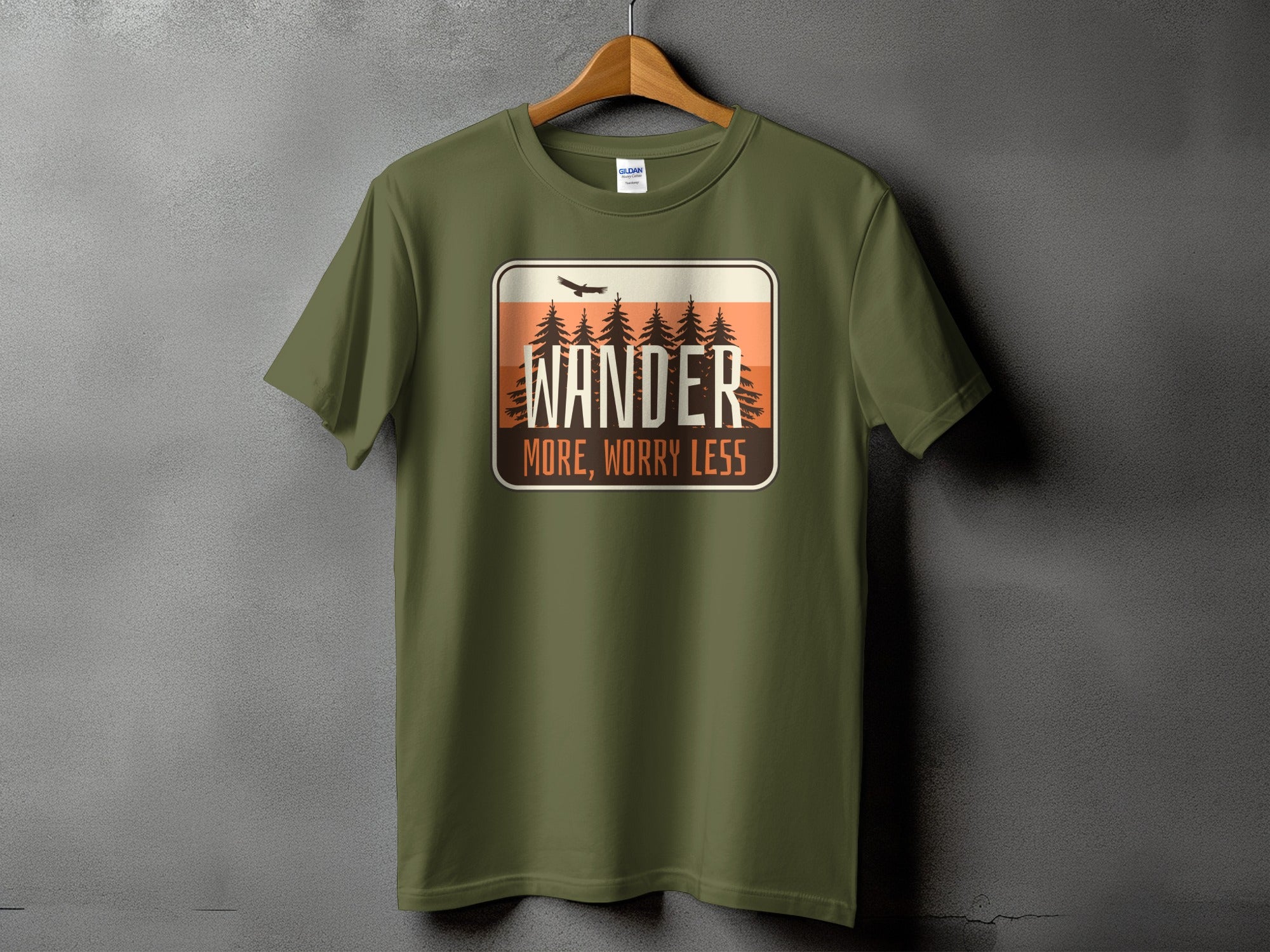 Green t-shirt with "Wander More, Worry Less" graphic and pine trees.
