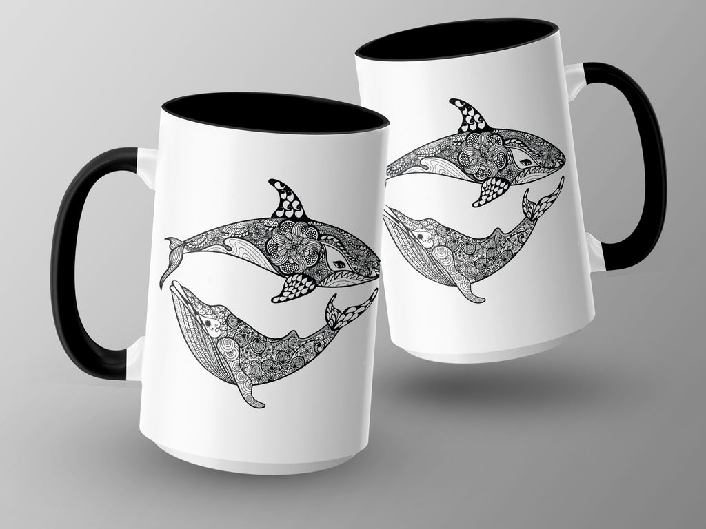 Two white mugs with black handles feature intricate black and white whale and orca designs.