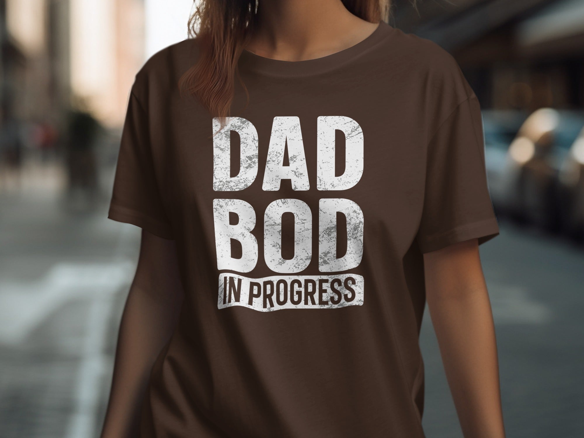 Brown t-shirt with white distressed text that reads "DAD BOD IN PROGRESS".