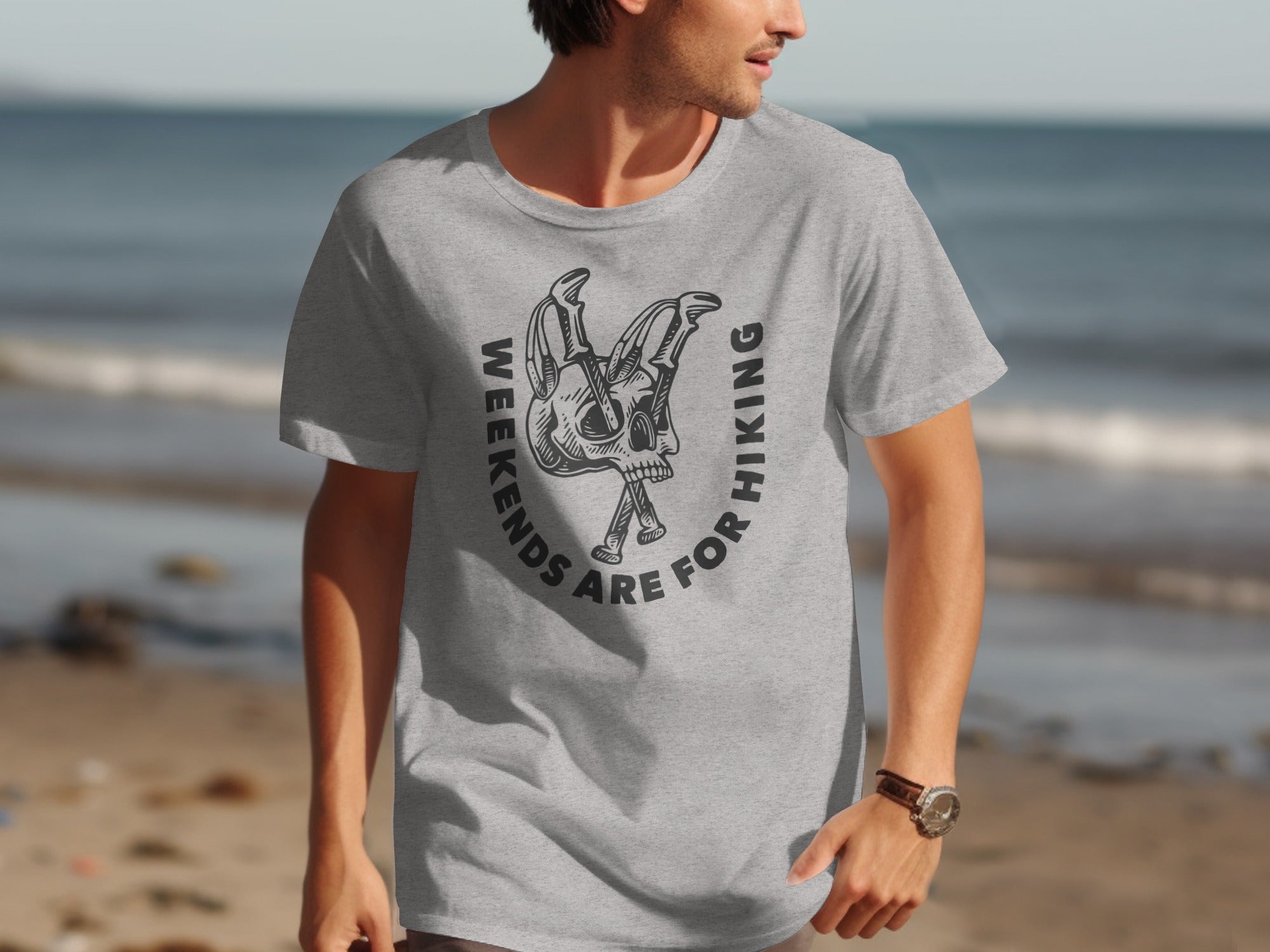Grey t-shirt with a circular graphic featuring a skull and hiking poles, reading "Weekends are for Hiking".