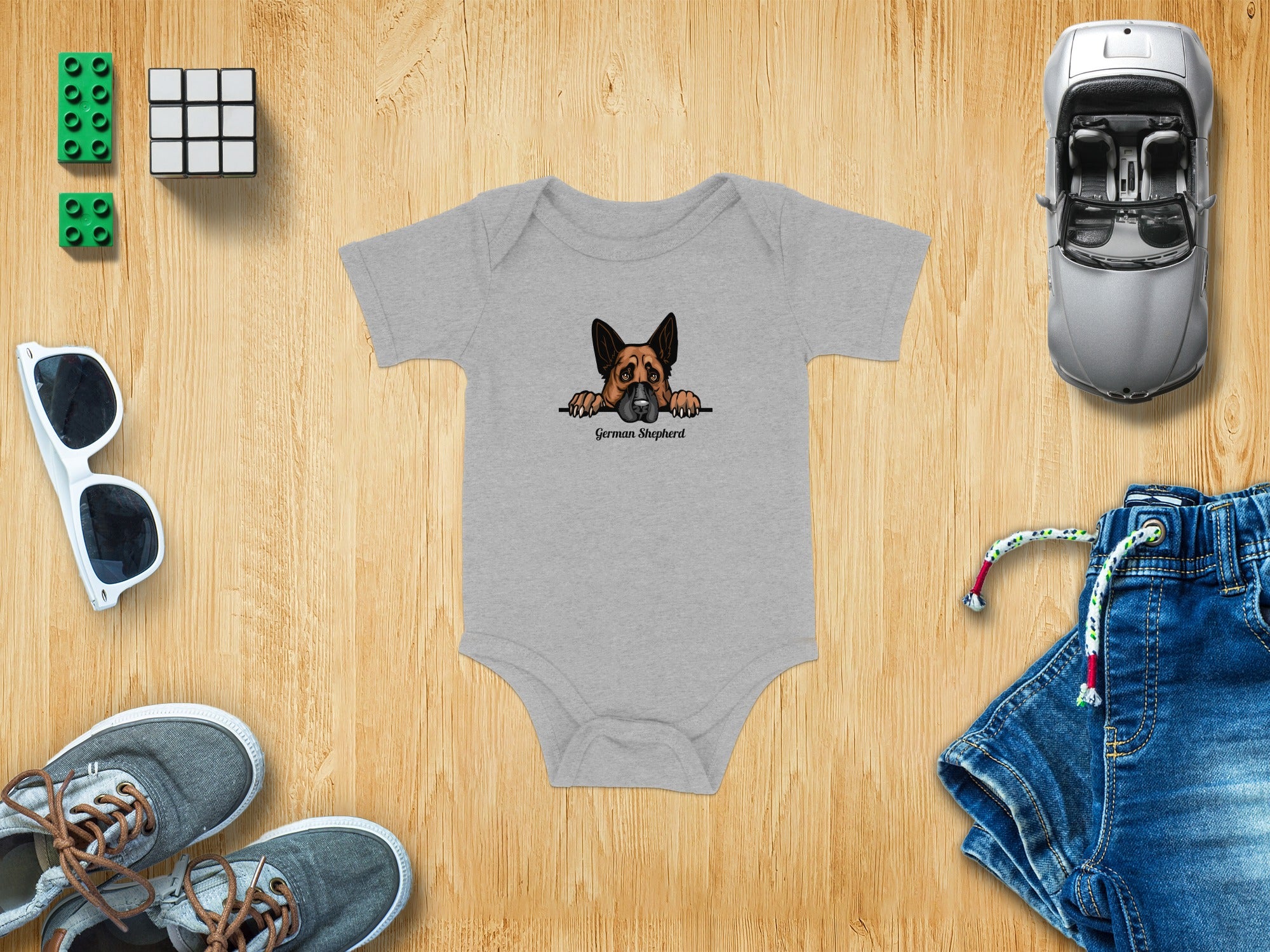Grey baby onesie with a German Shepherd cartoon graphic and text.