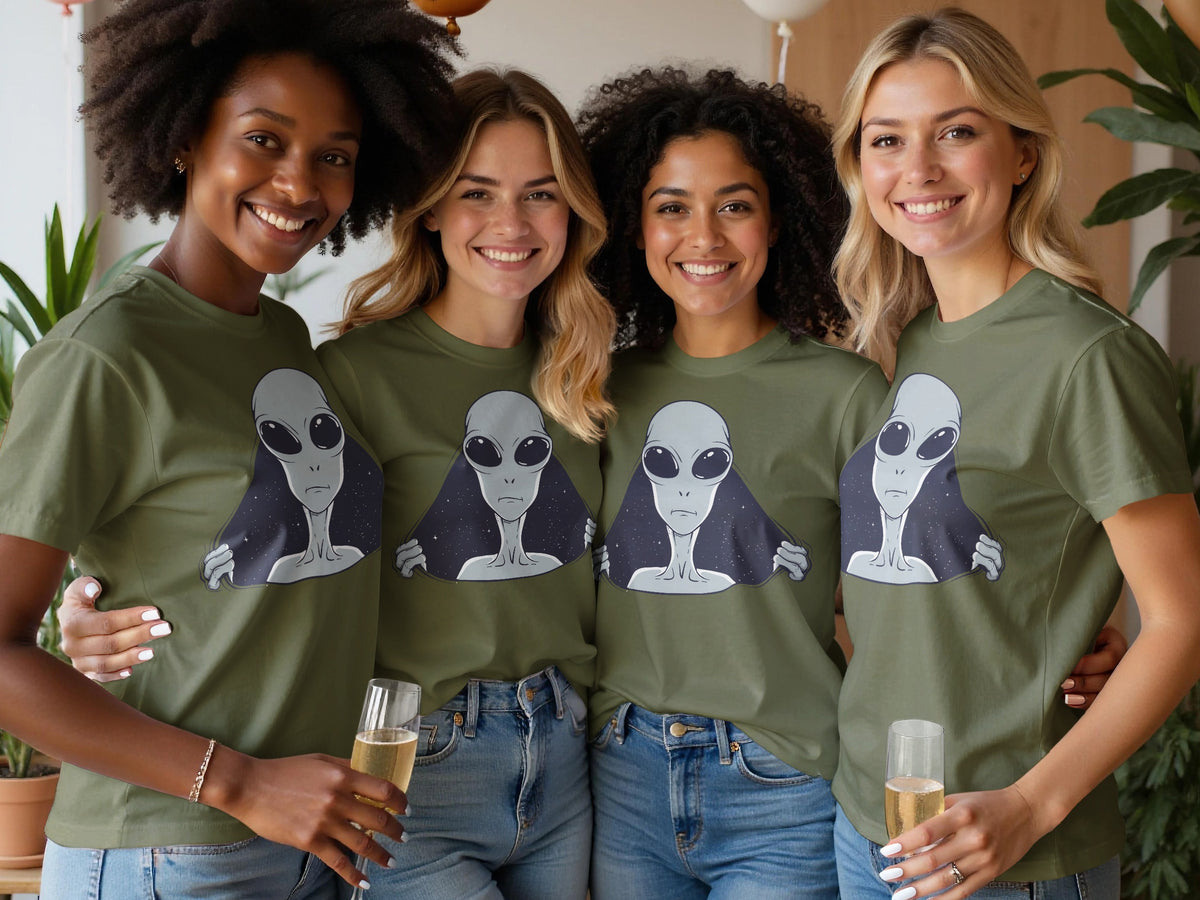 Four women in olive green t-shirts with alien graphics, holding champagne.