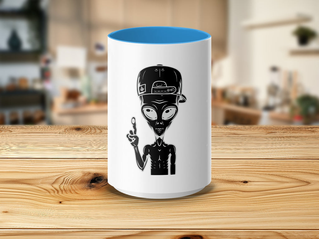 White mug with blue interior featuring a black alien wearing a backwards baseball cap.