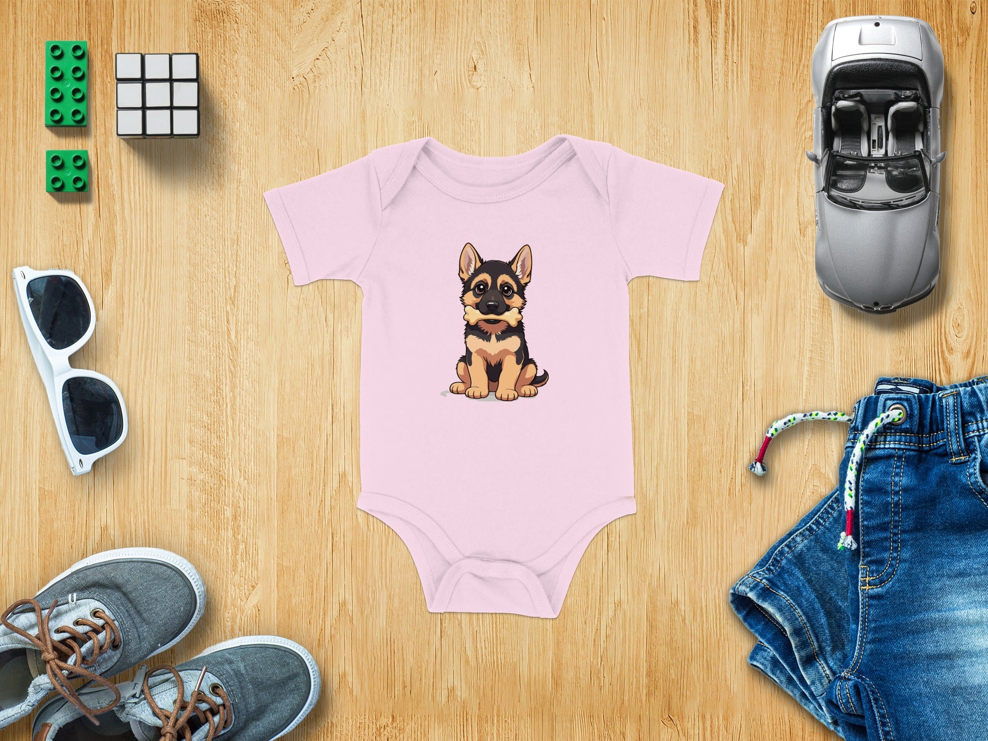 Pink baby onesie with a cartoon German Shepherd puppy graphic.