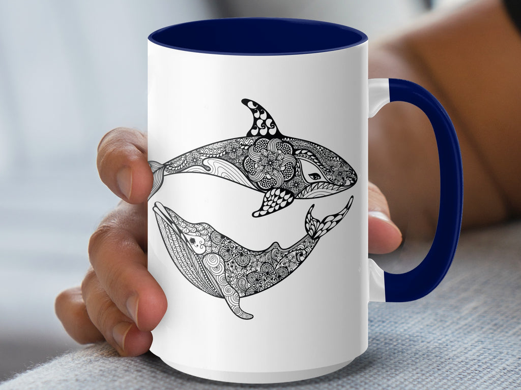 White mug with navy handle features a black-and-white orca and whale illustration.