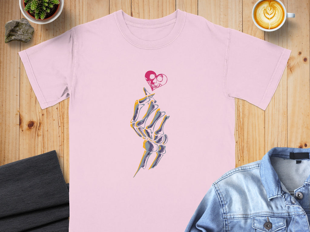 Pink t-shirt with skeleton hand making heart gesture graphic.